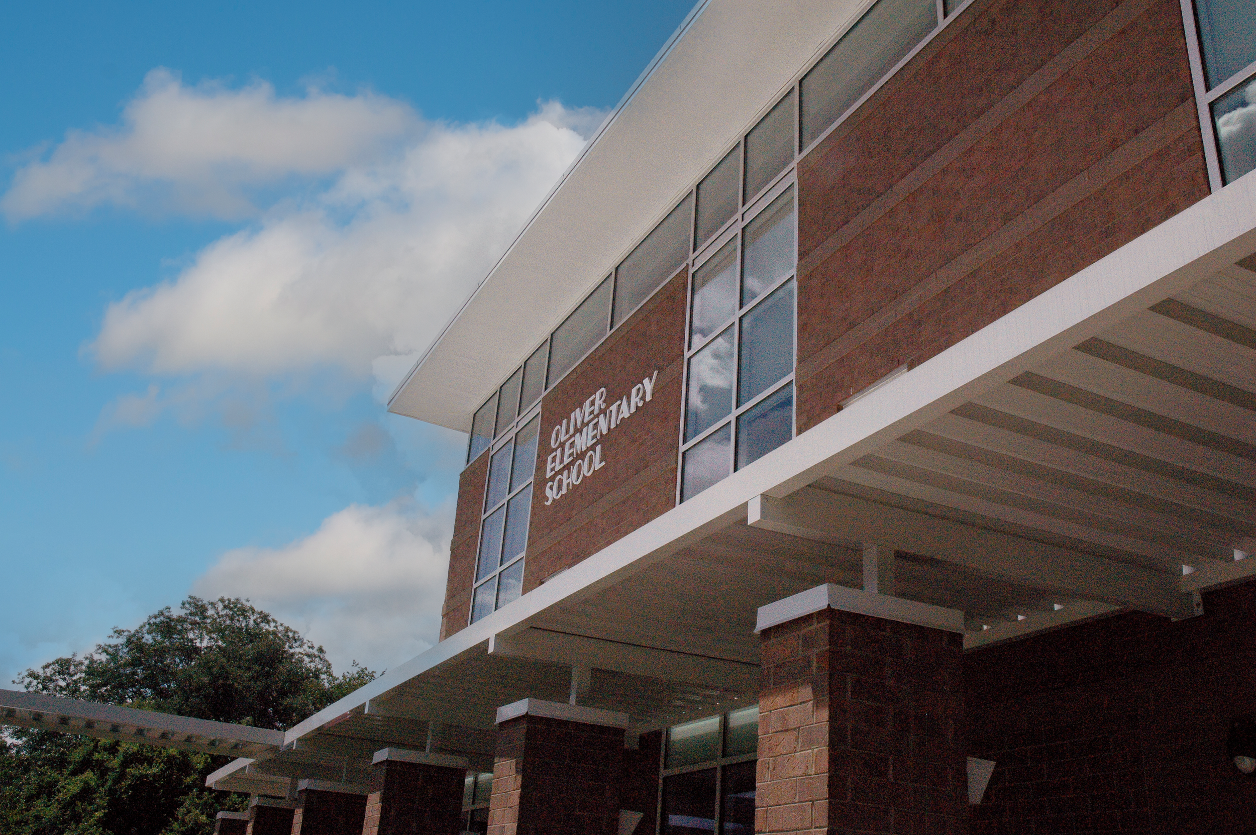Close up view of Oliver Elementary School with large glass window,  with a modern brick and flat roof.  - project by B Group Architecture, Inc
