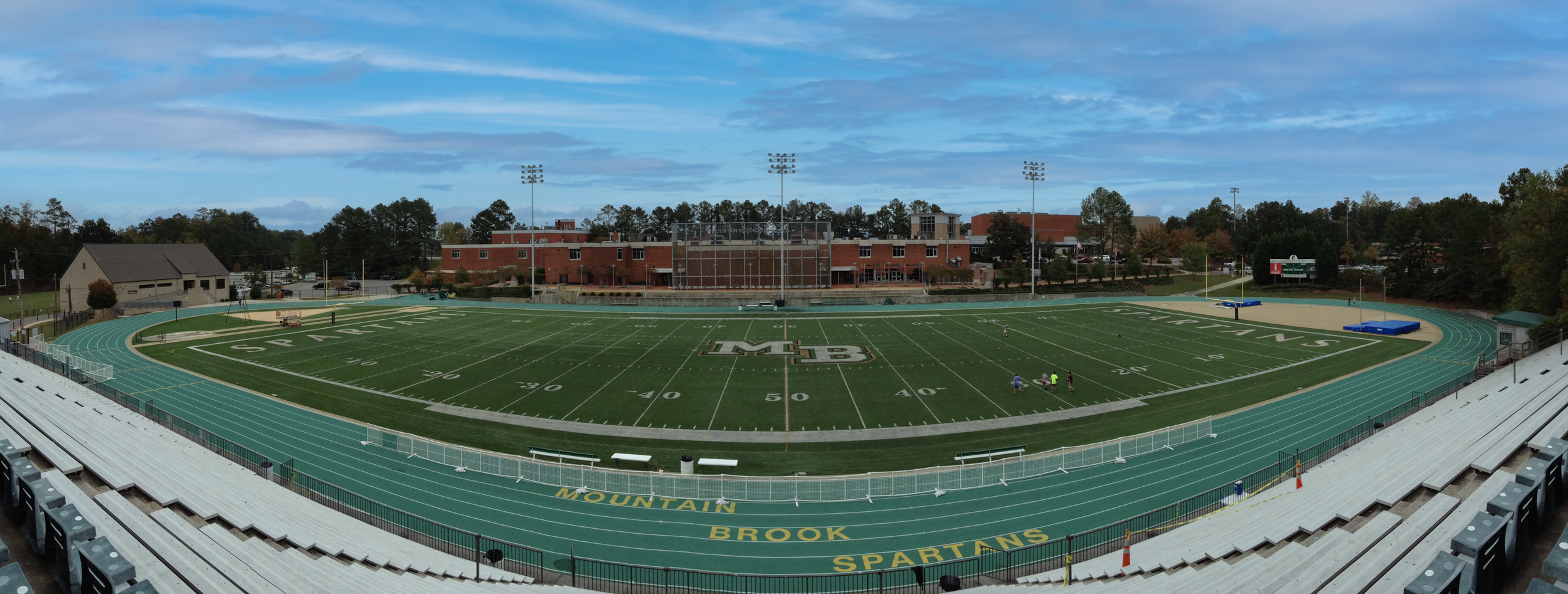 Panoramic view of Mountain Brook High School football field with a running track,  stadium bleachers and the school in the background. project by B Group Architecture, Inc.