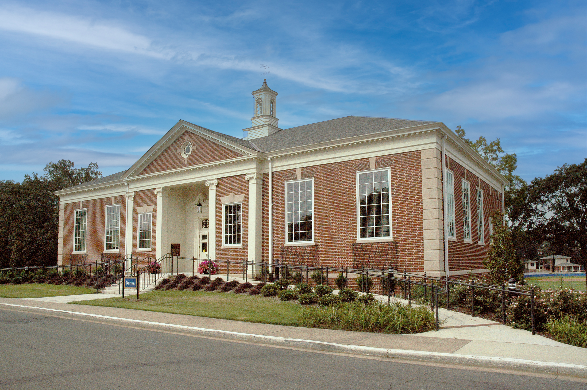 Norton library renovation has traditional red brick and cast stone trim, large windows, and a traditional cupola on the roof, set on a Snead State college campus. - project by B Group Architecture, Inc.