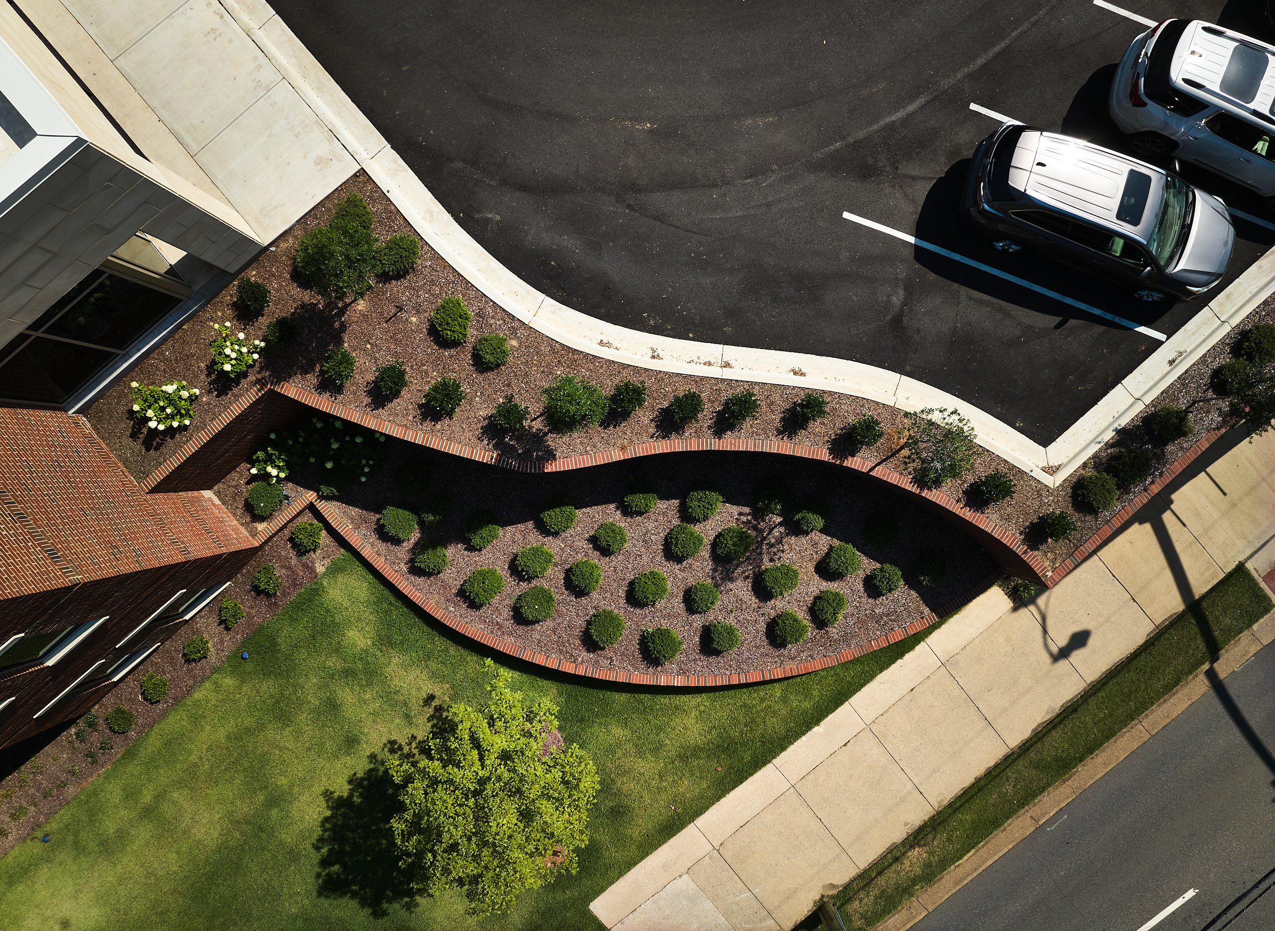Aerial view of a University parking lot with serpentined retaining wall and landscaping-project by B Group Architecture, Inc.