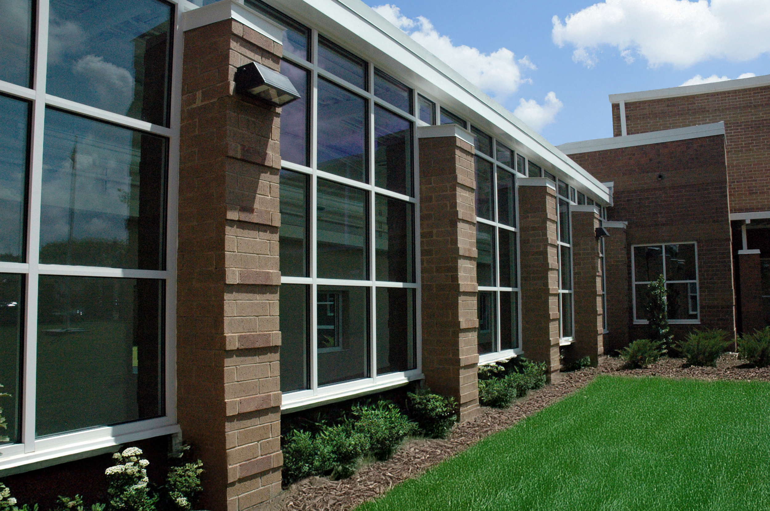 Exterior of Oliver Elementary School with large glass windows,  with a modern brick and glass exterior.  - project by B Group Architecture, Inc.