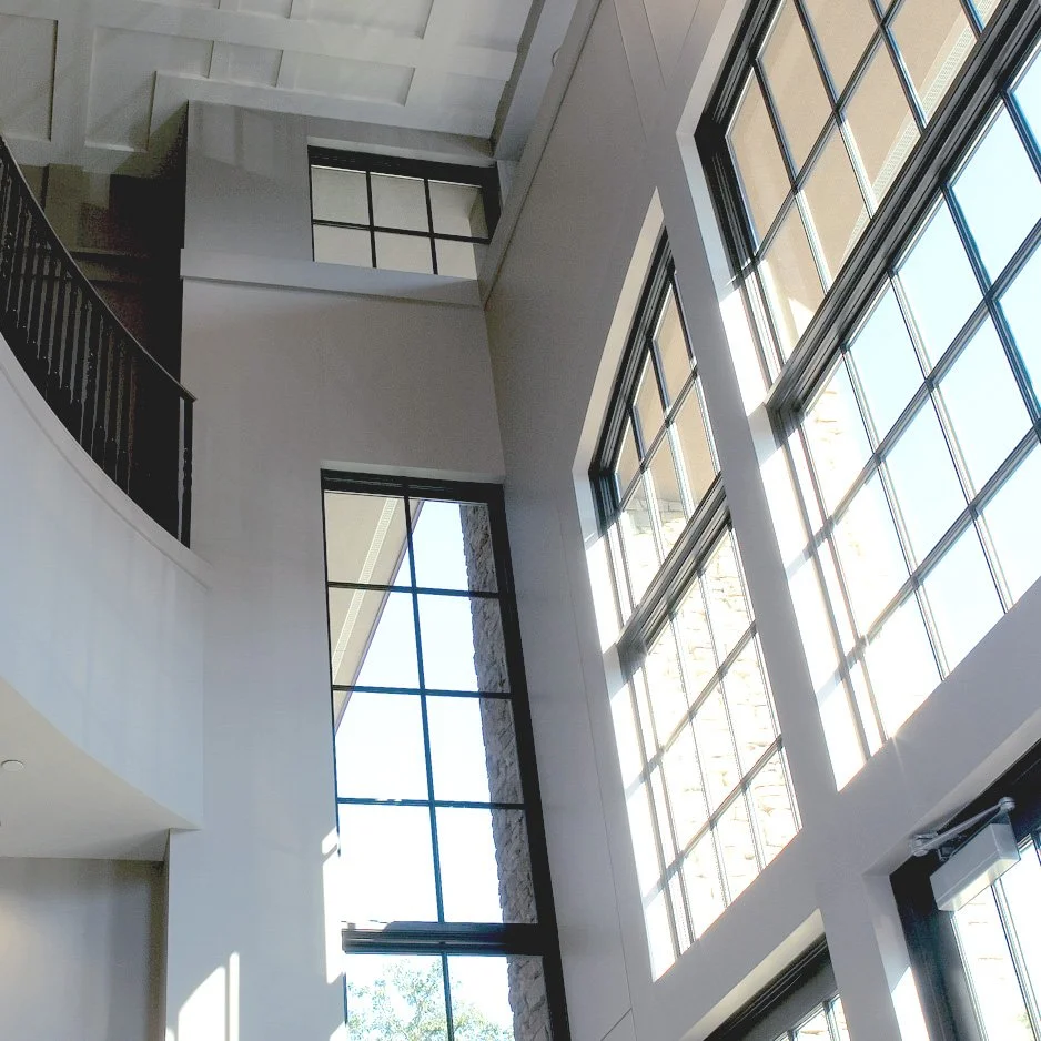 Interior view of a modern building with high ceilings, large floor-to-ceiling windows   project by B Group Architecture, Inc.