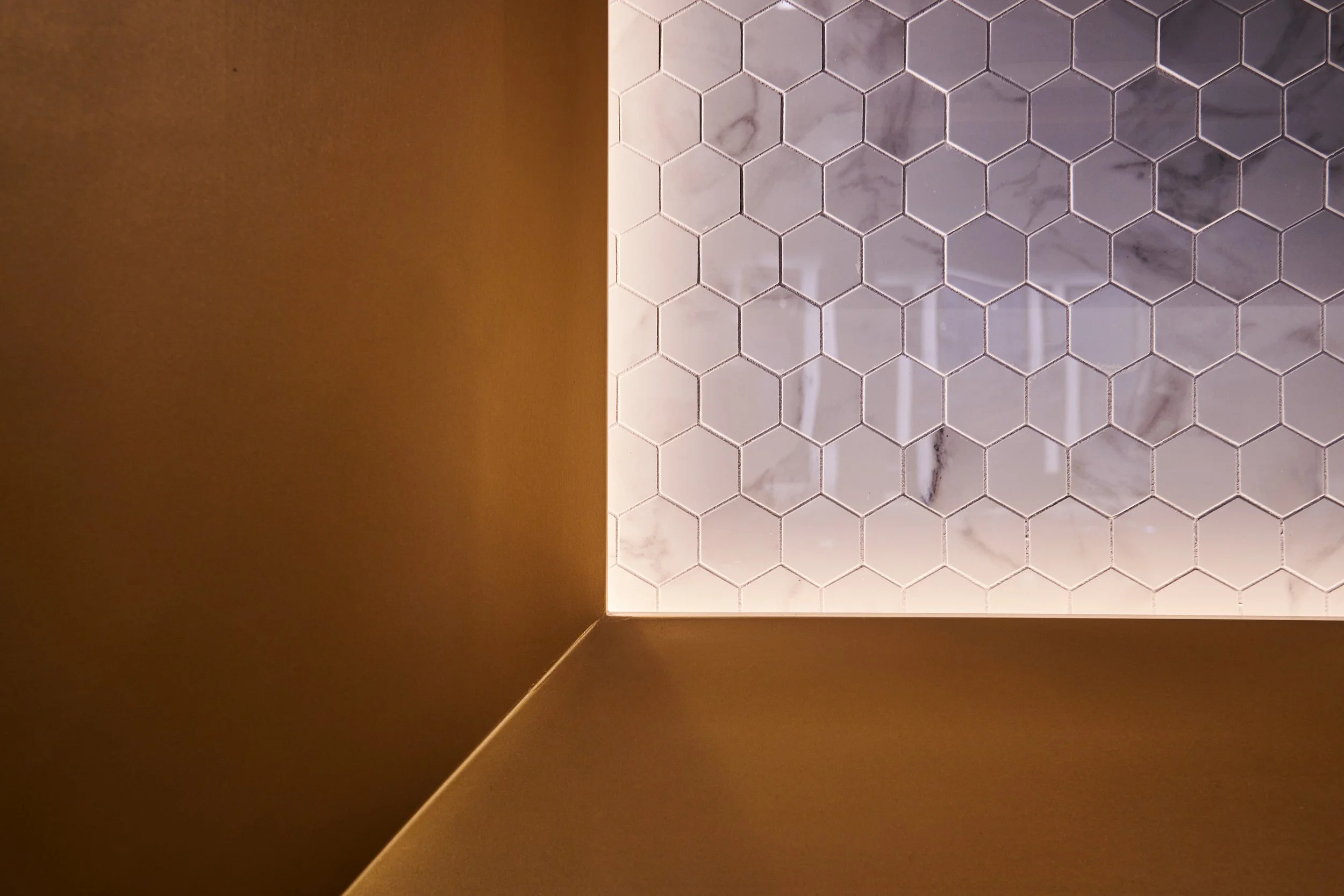 Jewelry display case with chamfered gold accent frame and marble tile. project by B Group Architecture, Inc 