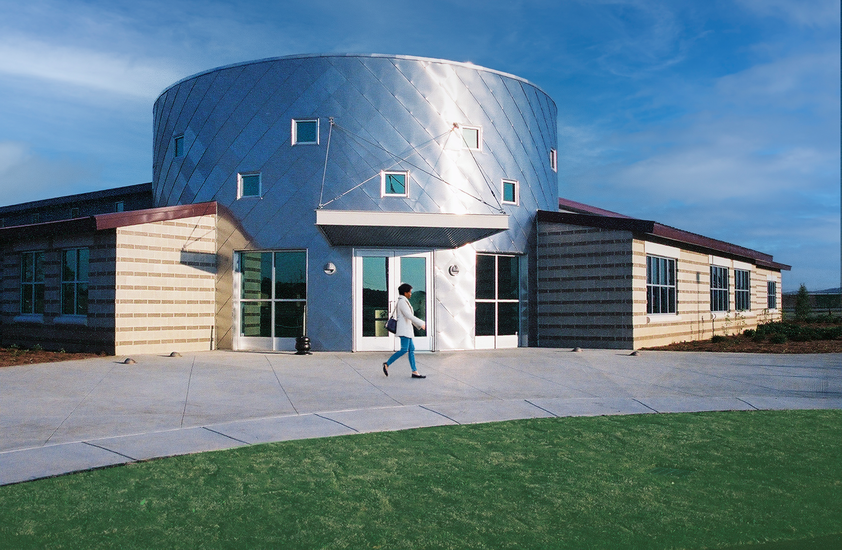 Exterior view of Talledega Super Speedway showcasing a round metal siding entrance. project  by B Group Architecture, Inc.  