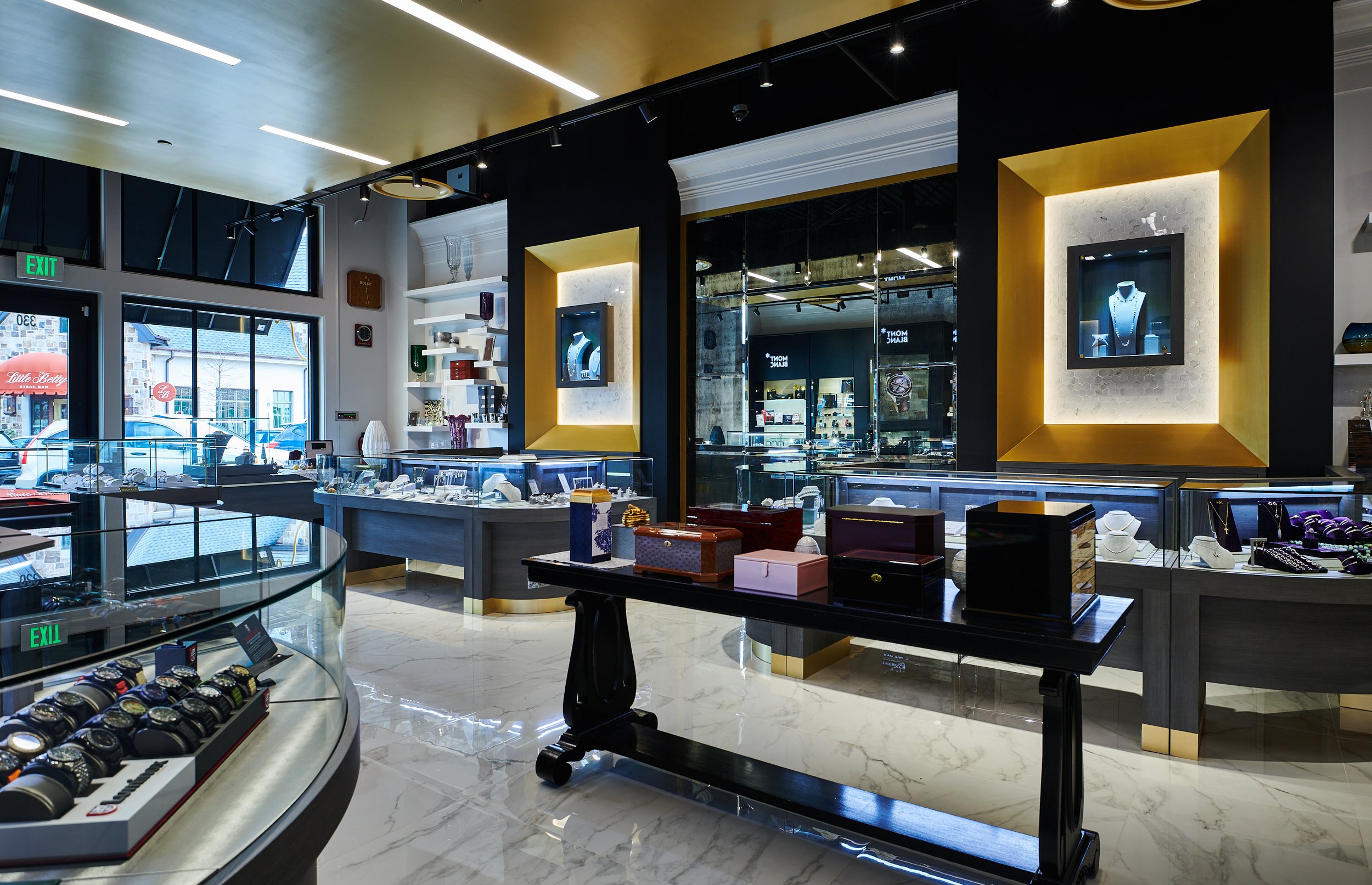 Interior of Barton Clay Fine Jewelers with display cases, shelves of jewelry, and a gold ceiling cloud. project by B Group Architecture, Inc 