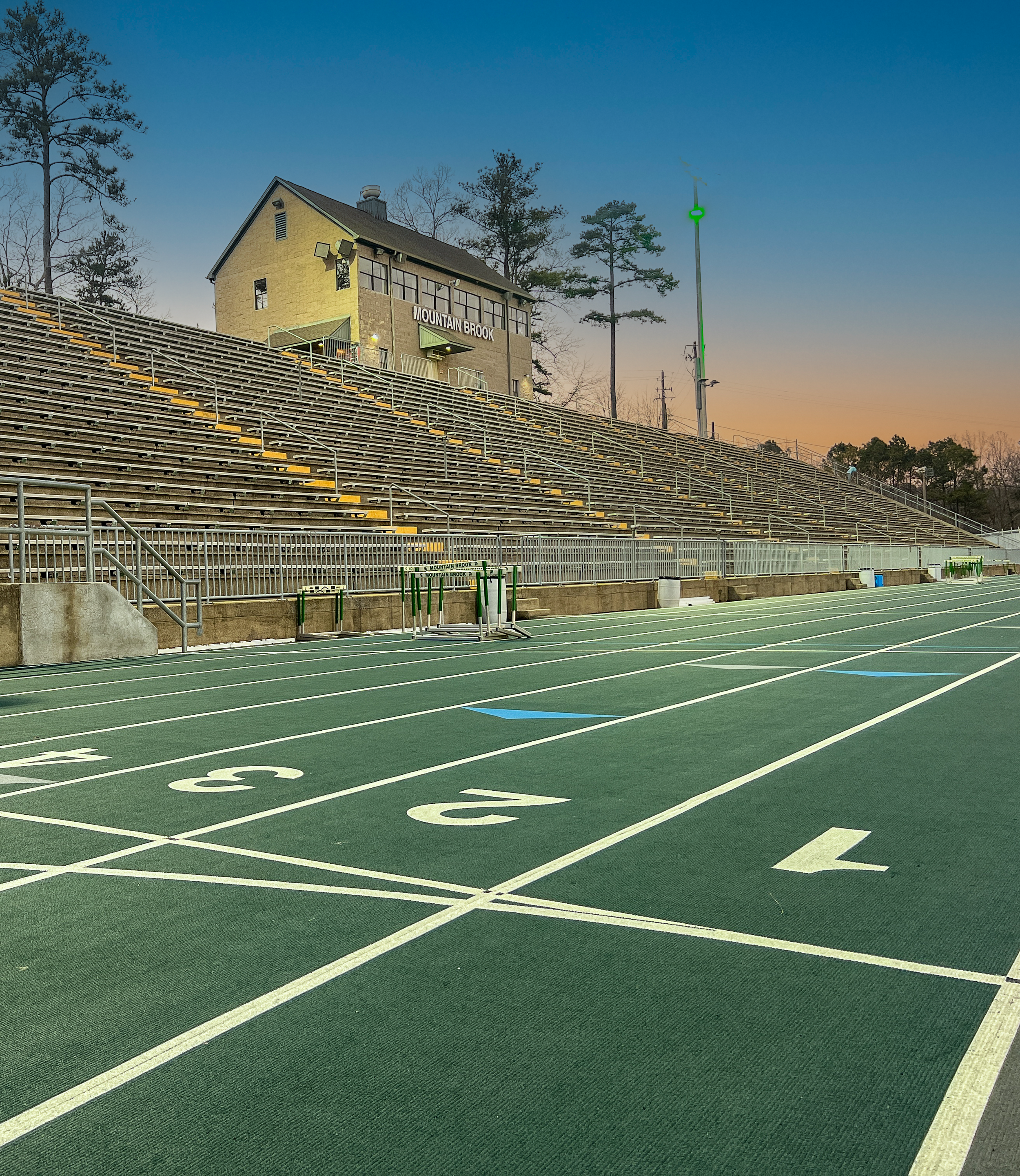 View of Mountain Brook High School running track, stadium bleachers and the field house in the background. project by B Group Architecture, Inc.