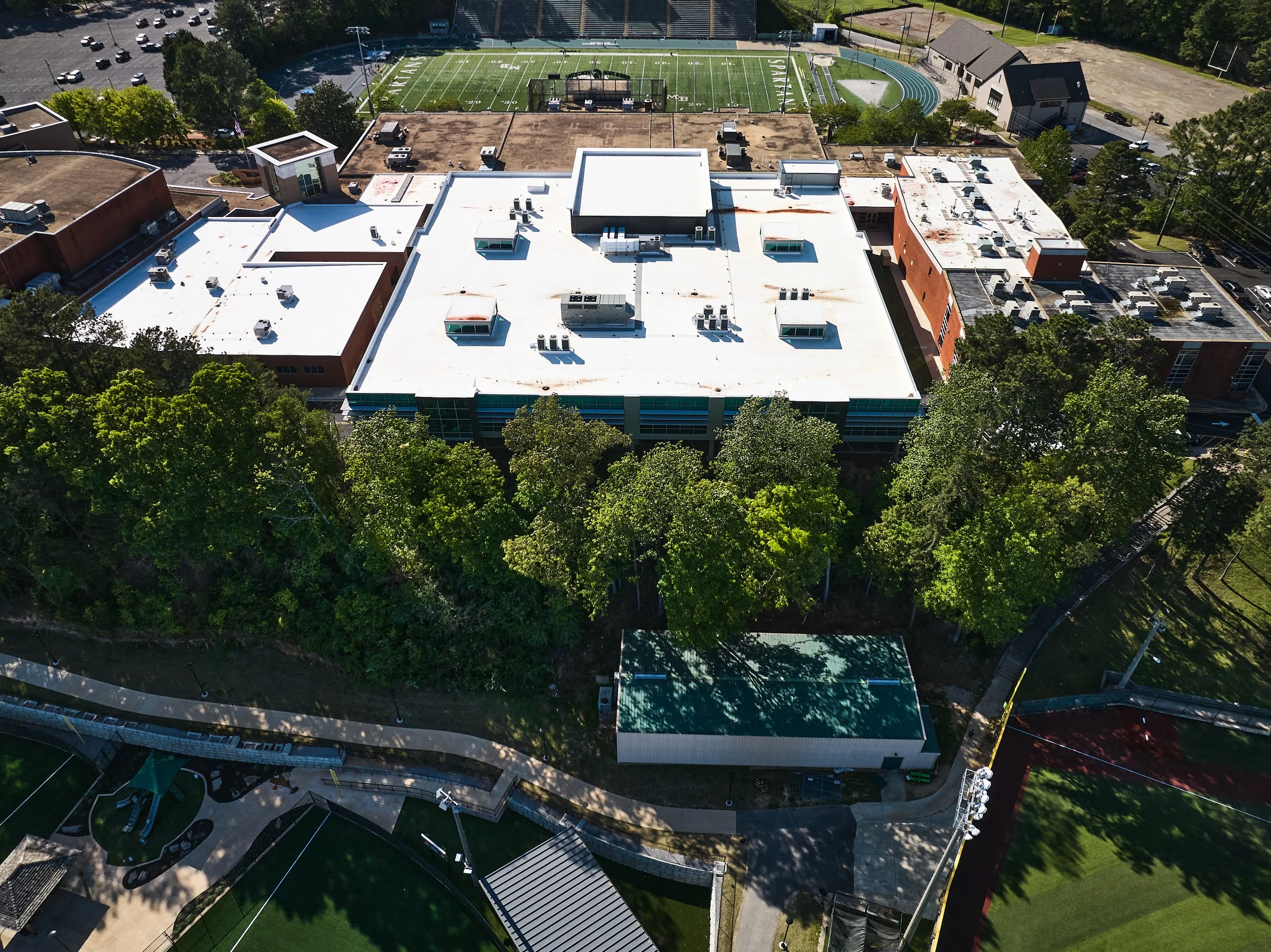 An aerial view of the Mountain Brook High School showing a 2 story addition with a TPO roof, clerestory and curtainwall glazing - project by B Group Architecture, Inc.