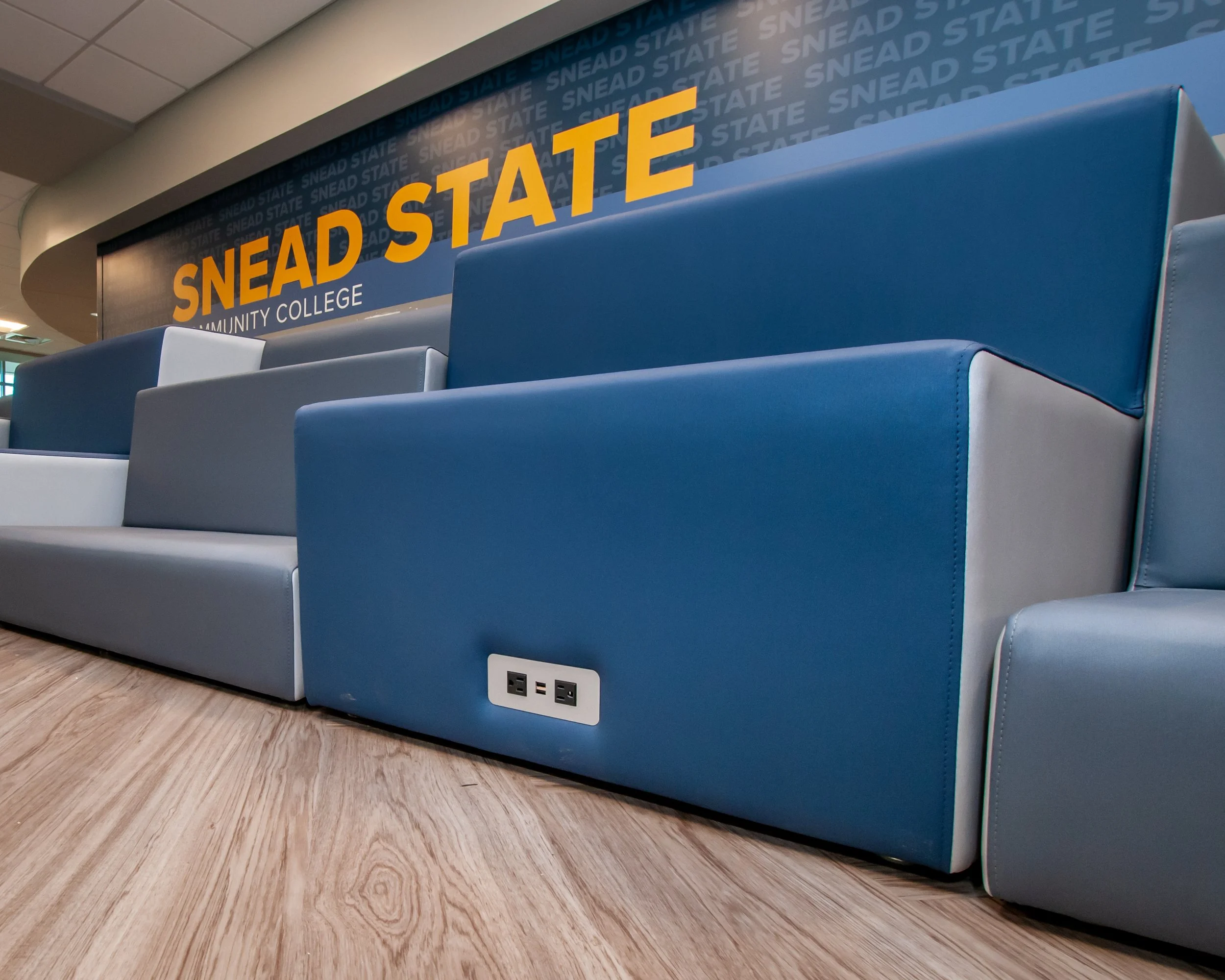 Blue, gray, and white cushioned tiered seats at Snead State Community College.  Furniture integrates power and data.