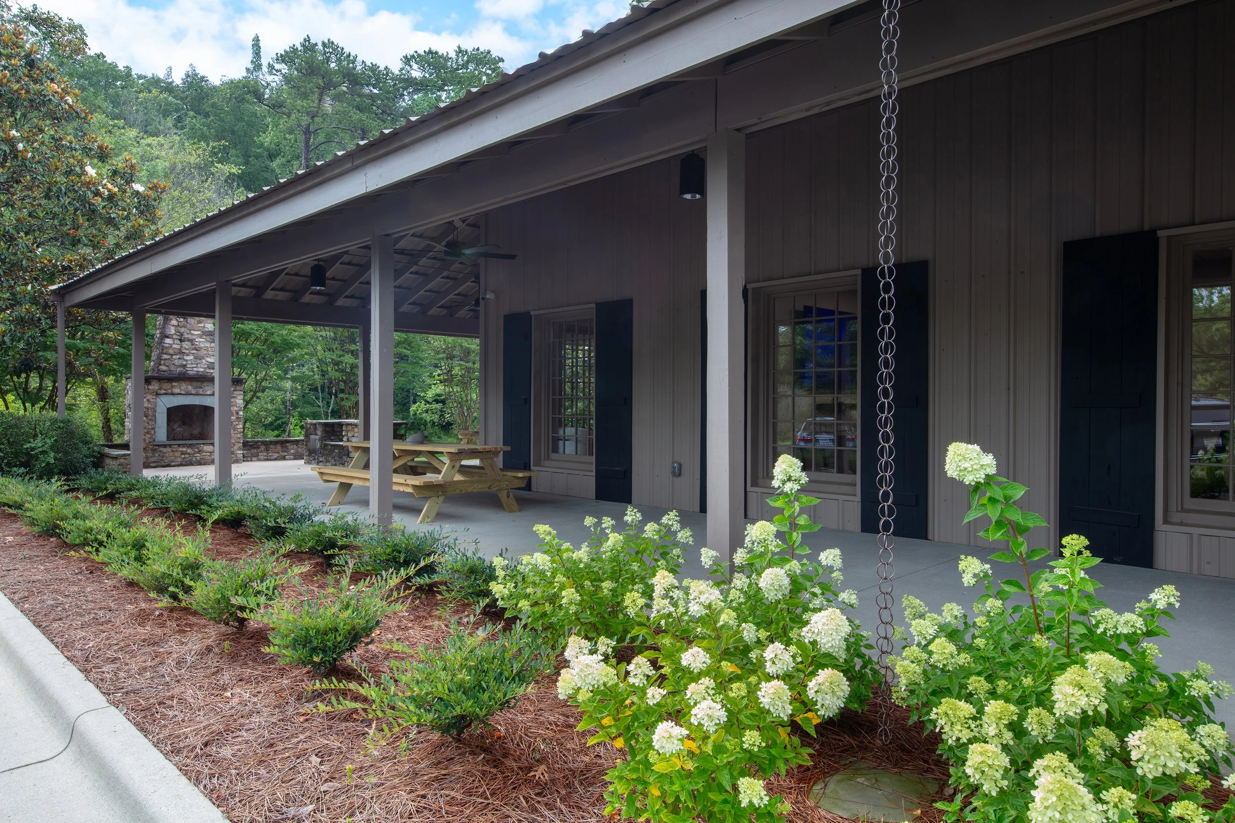 Brasfield & Gorrie Training and Development Center in Irondale, AL. Exterior view withe new paint, rain chains and a fire place beyond. project by B Group Architecture, Inc.