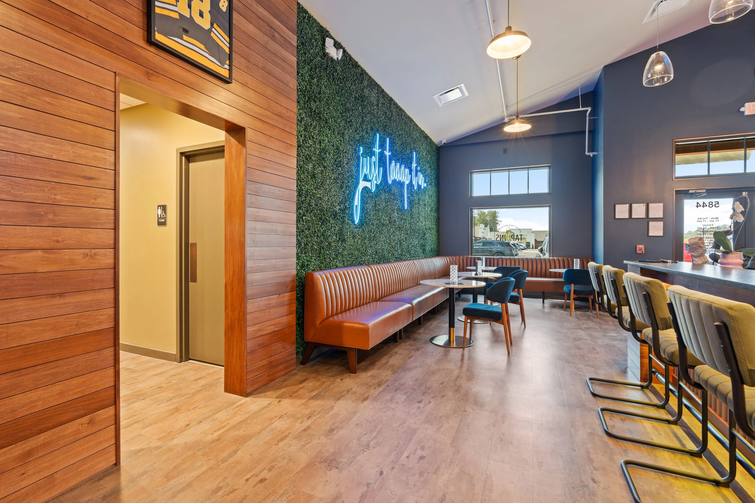 Tap Ins blends the excitement of a sports bar with the energy of an upscale game lounge . project by B Group Architecture, Inc