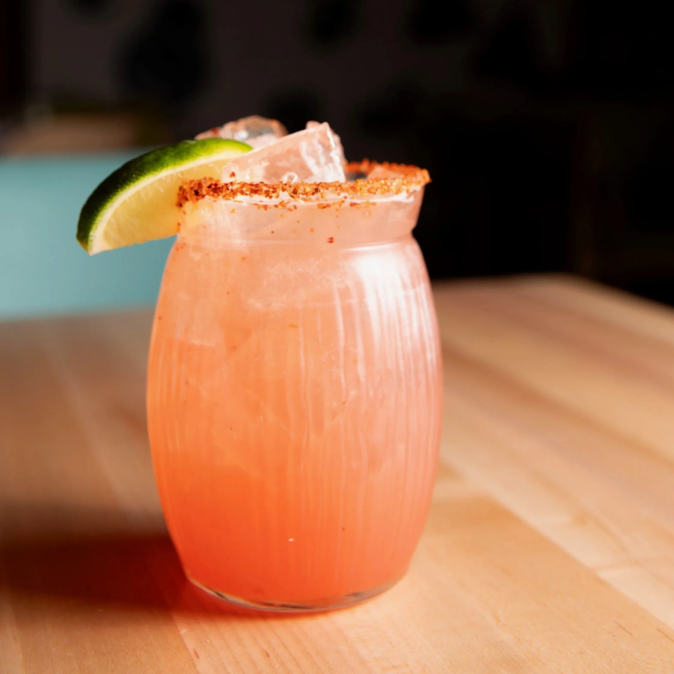 Group raising colorful cocktails over a table of shared Mexican dishes, seen from above.