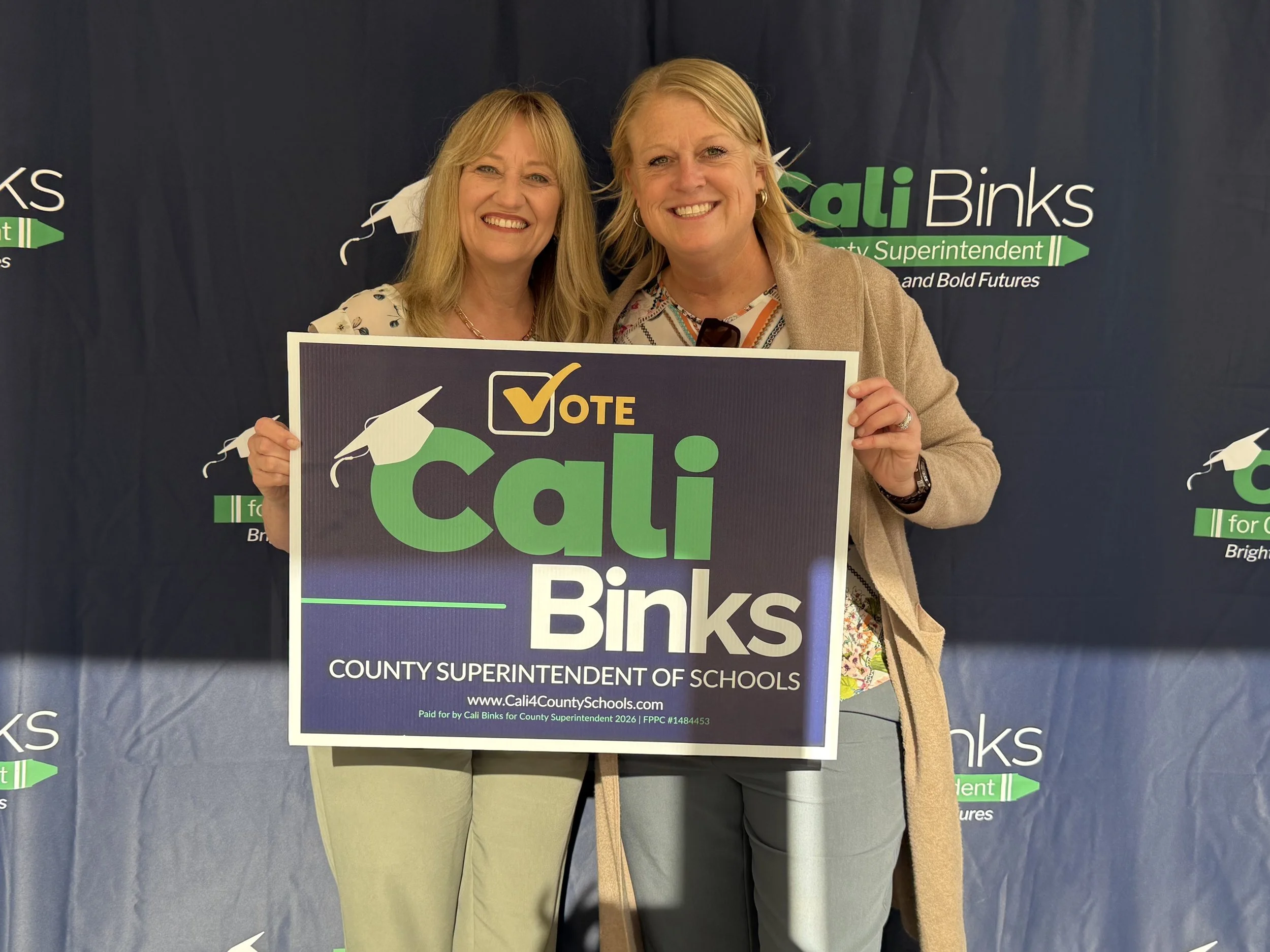 A community member holding a yard sign with Cali