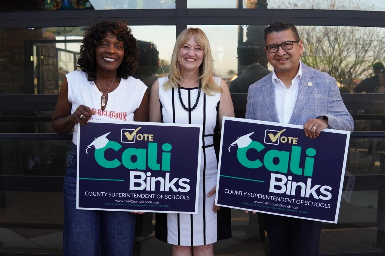 Mayor Acquanetta Warre, Cali Binks, and Supervisor Jesse Armendarez posing for a photo and holding up two yard signs.