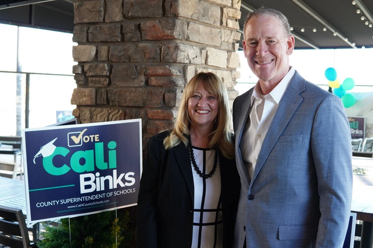 Dale Marsden, former superintendent of San Bernardino City Unified School District is posing with Cali next to a yard sign promoting Cali at the event. 