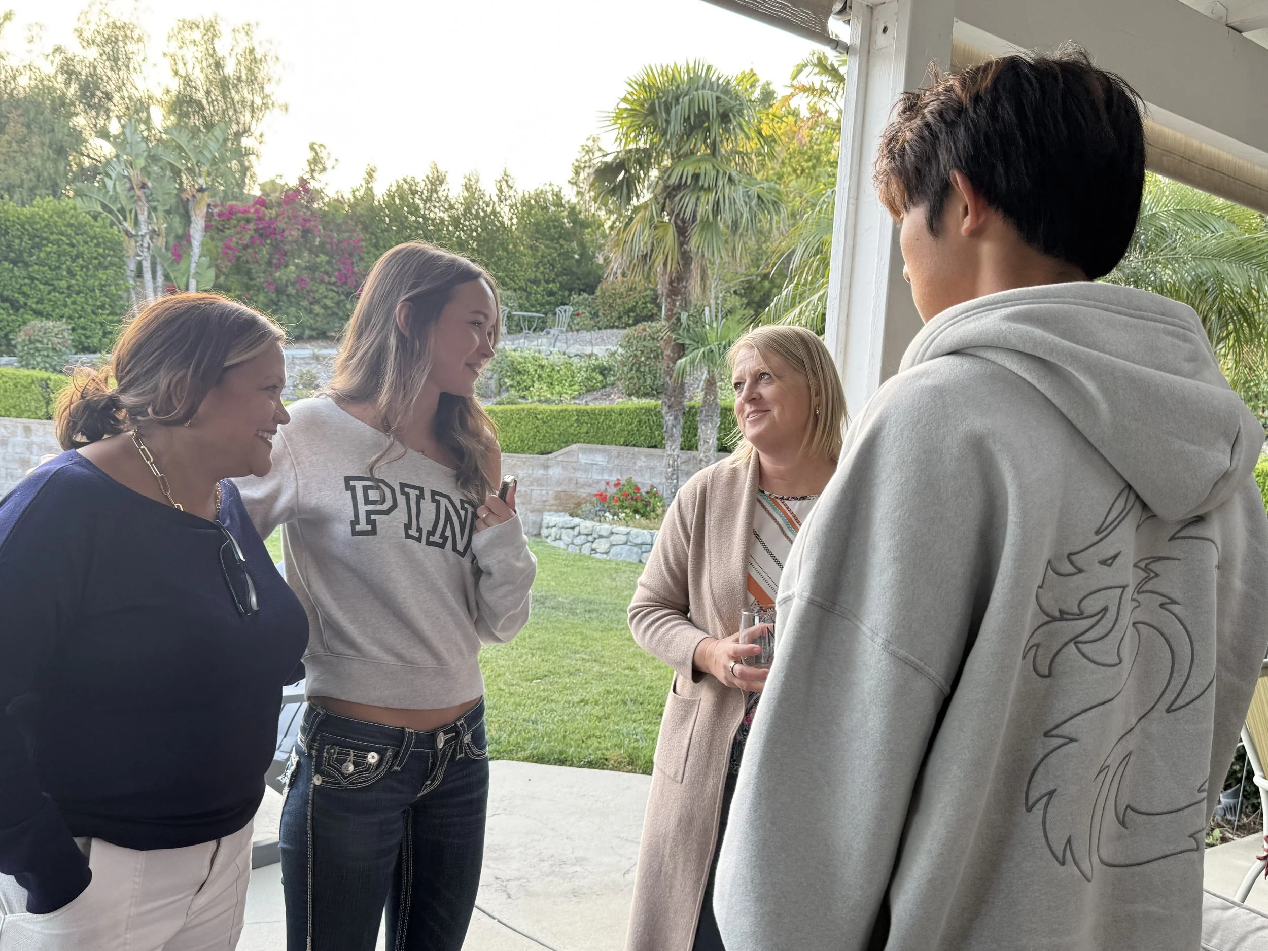 Two high school students speaking with two adults
