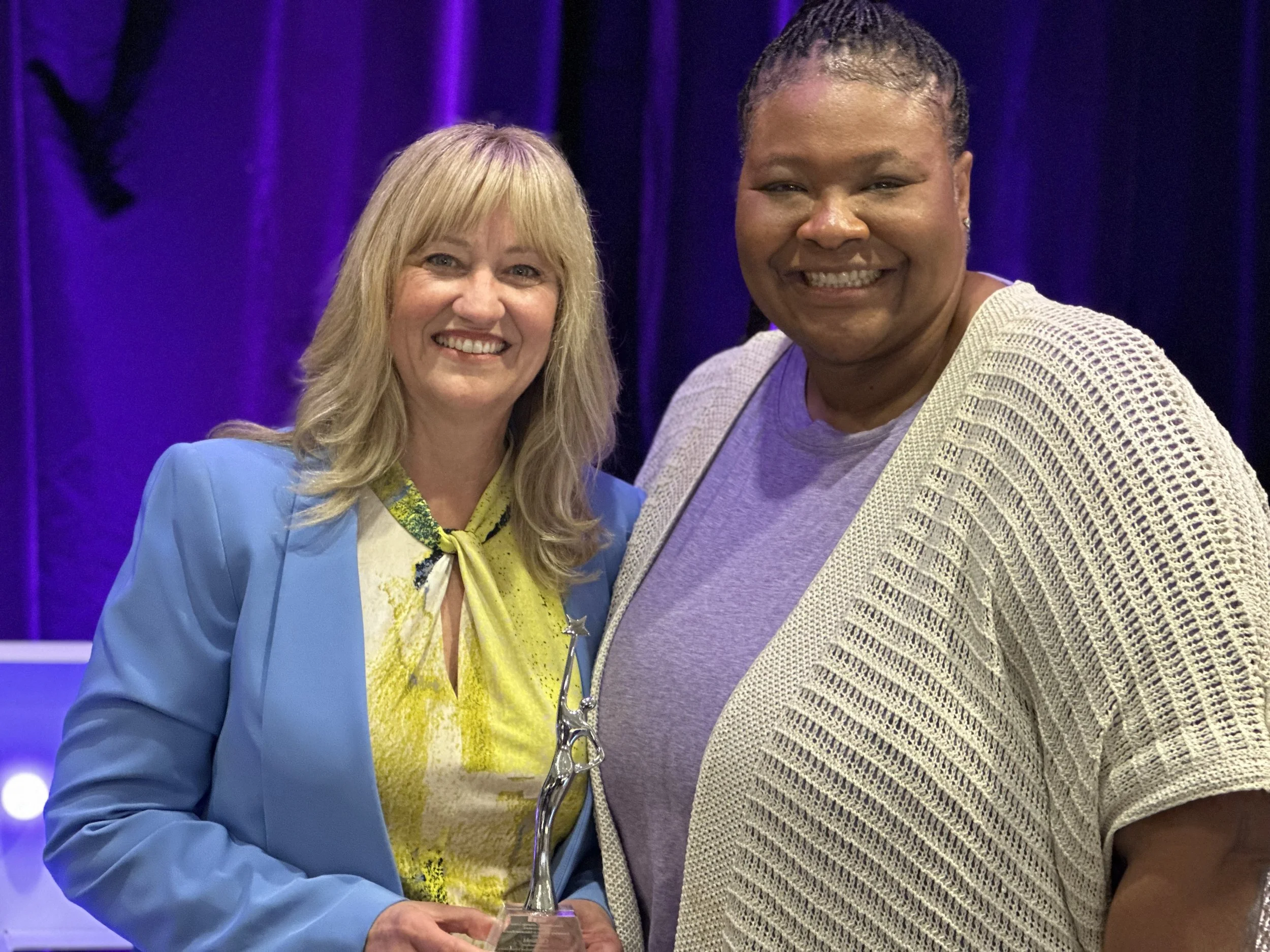 Cali holding an award posing for a photo next to Dr. Betters.
