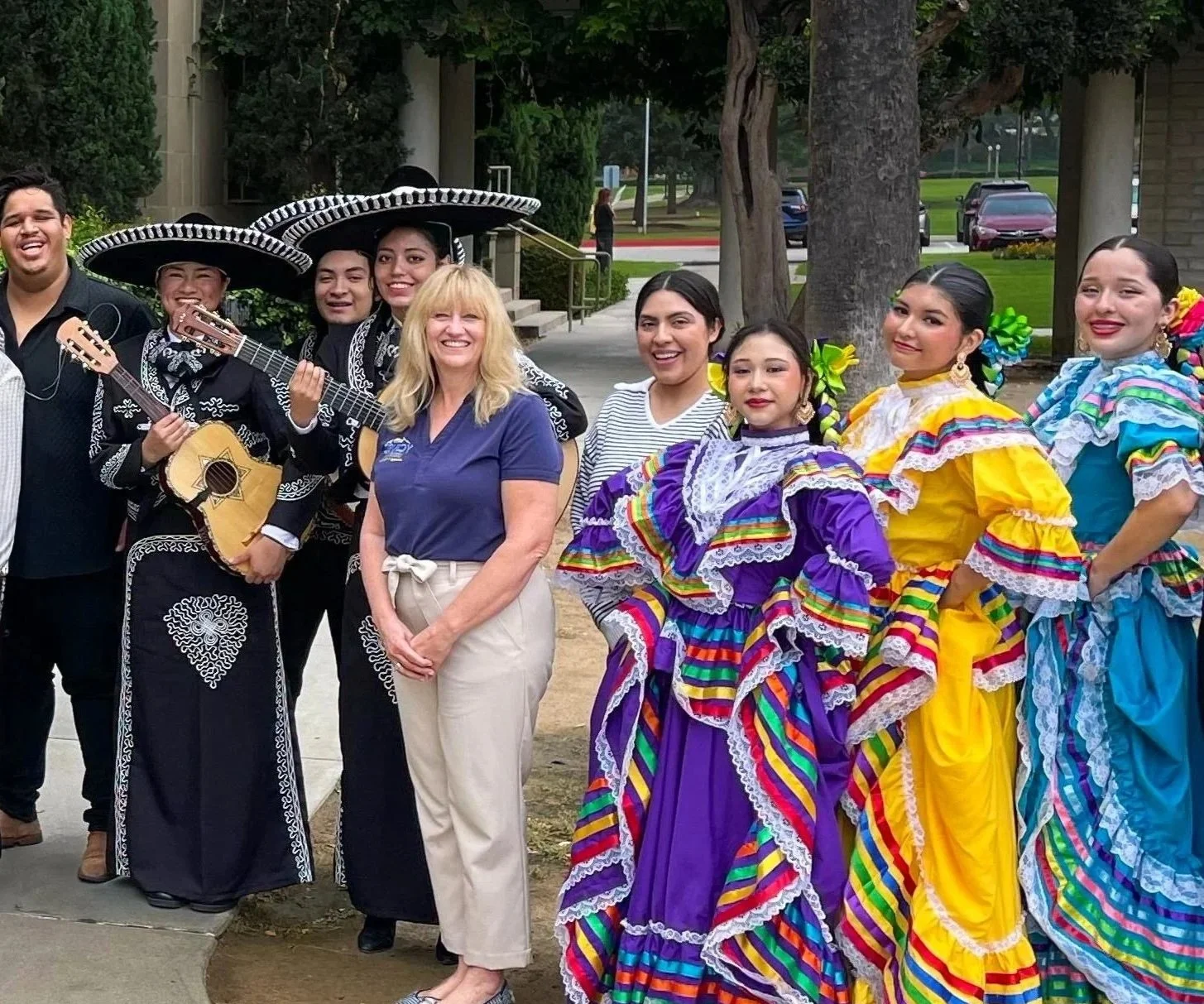 Cali posing with a mariachi band and student folklorico dancers.