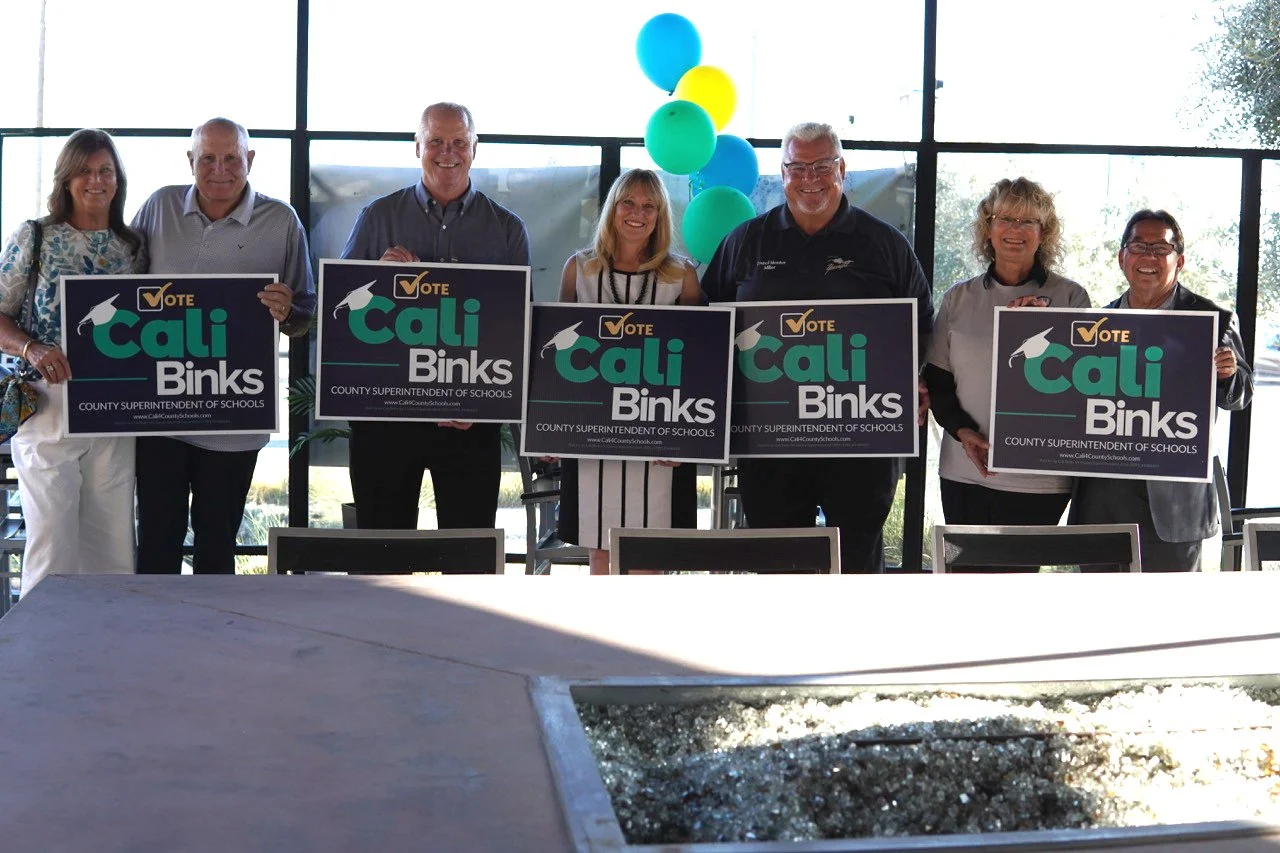 Cali Binks with her husband Kelly Binks, Norm Nunez, and four Yucaipa community members holding campaign yard signs. 