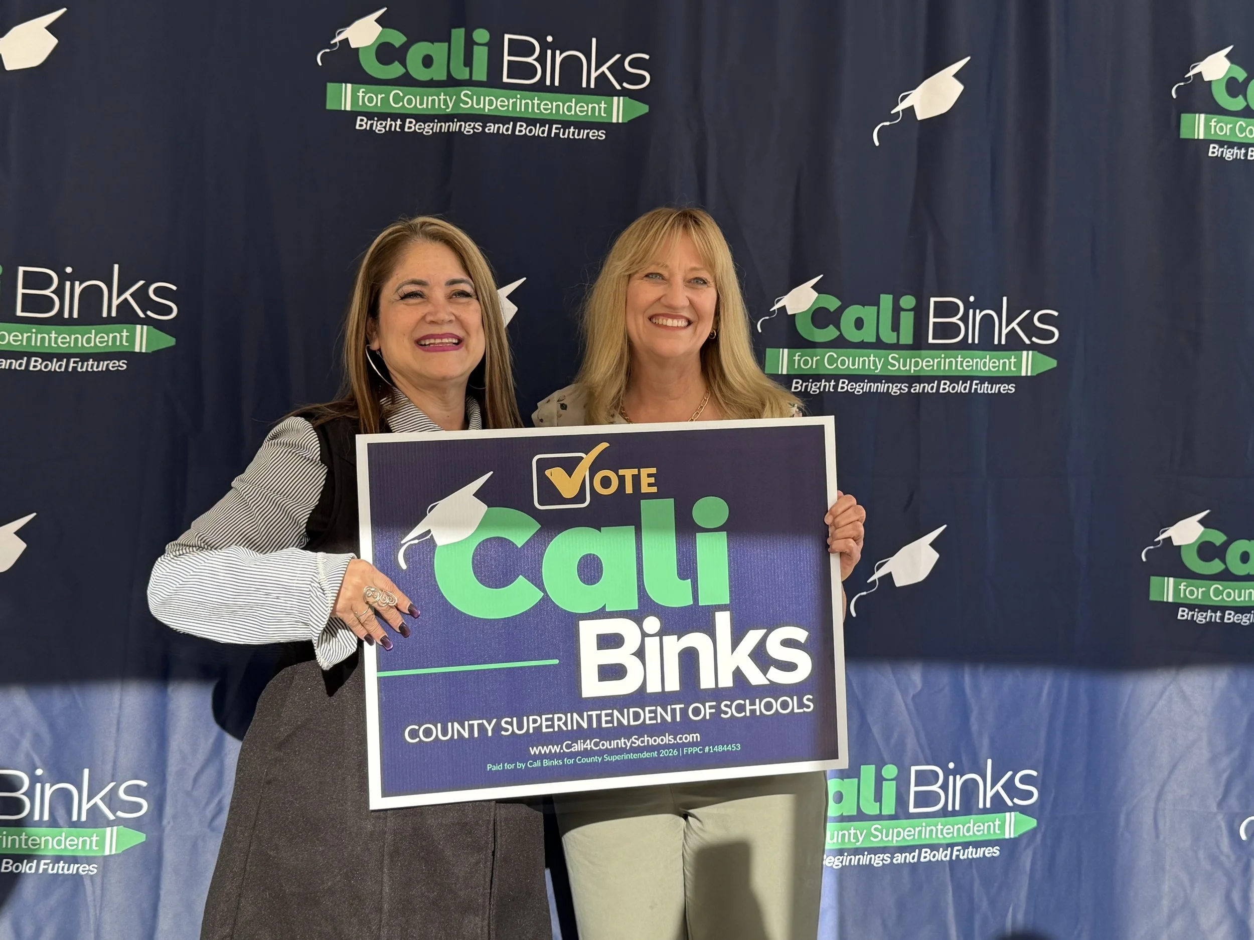 A community member holding a yard sign with Cali