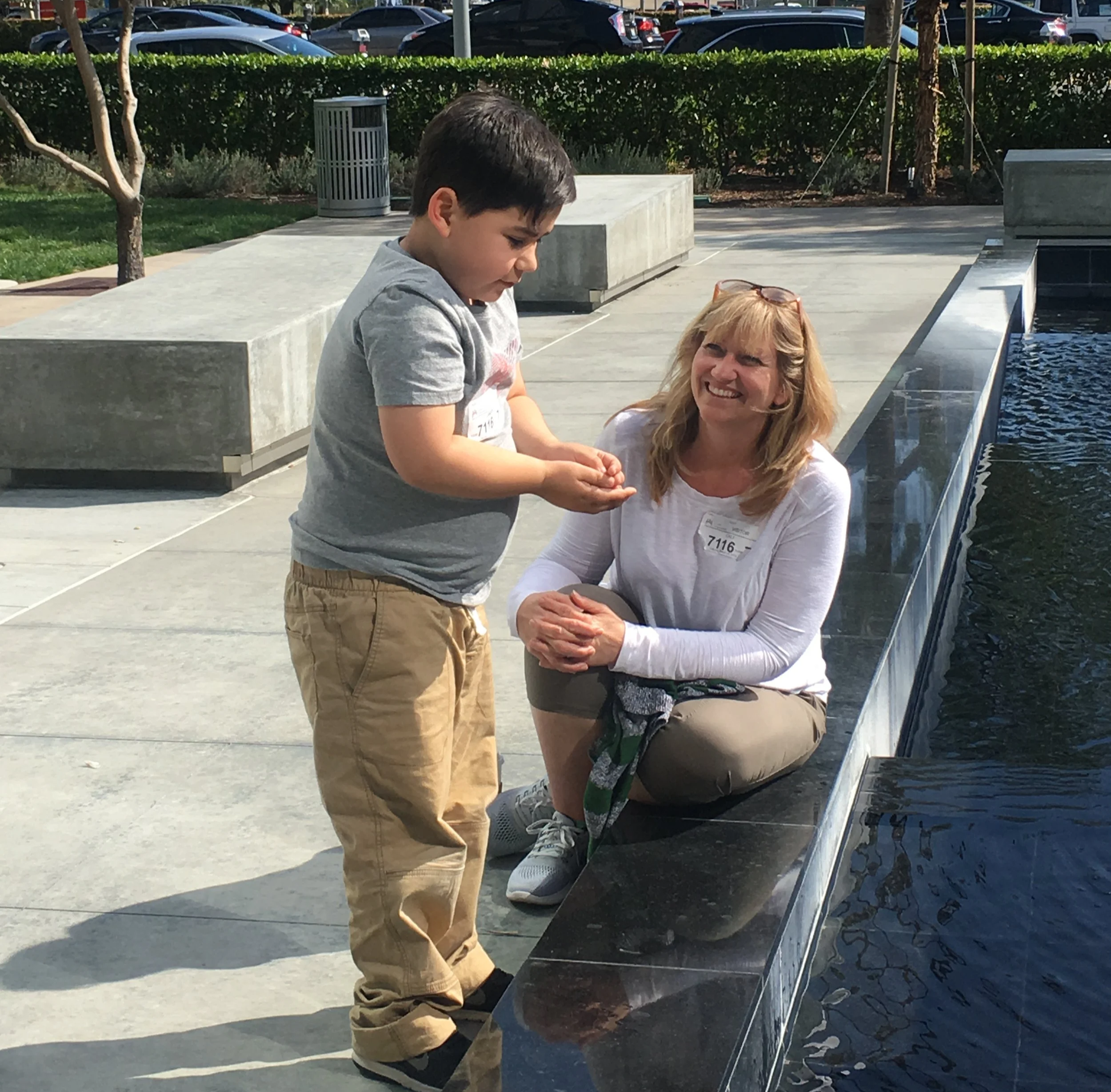 Cali talking to an elementary student next to a water fountain.