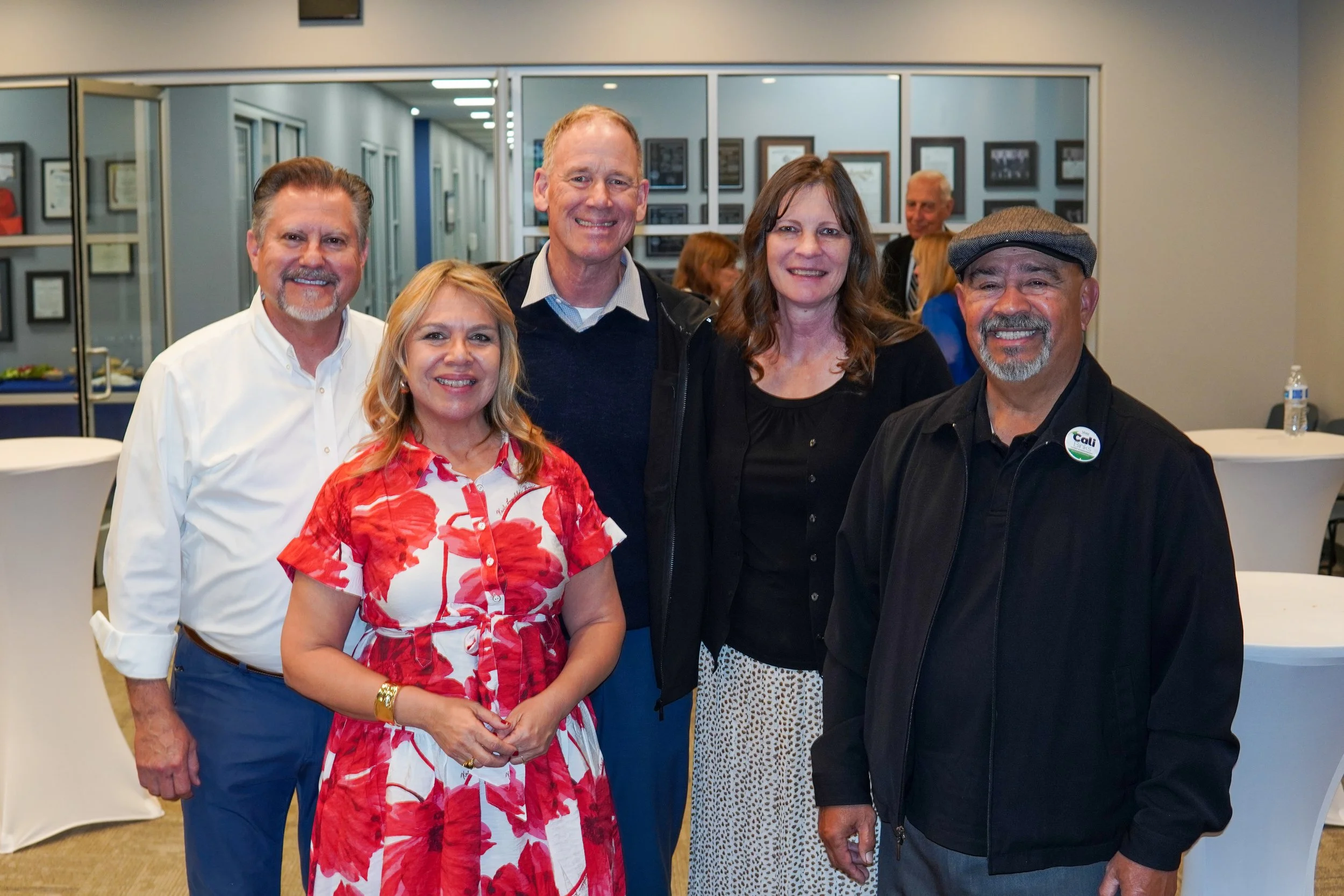 Five adults posing for a photo at the event.