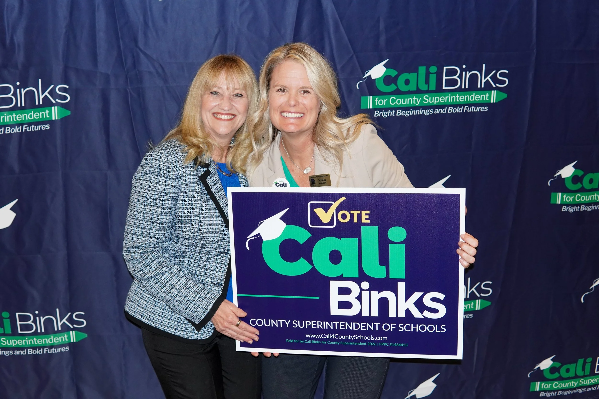 Cali next to an adult with a yard sign.