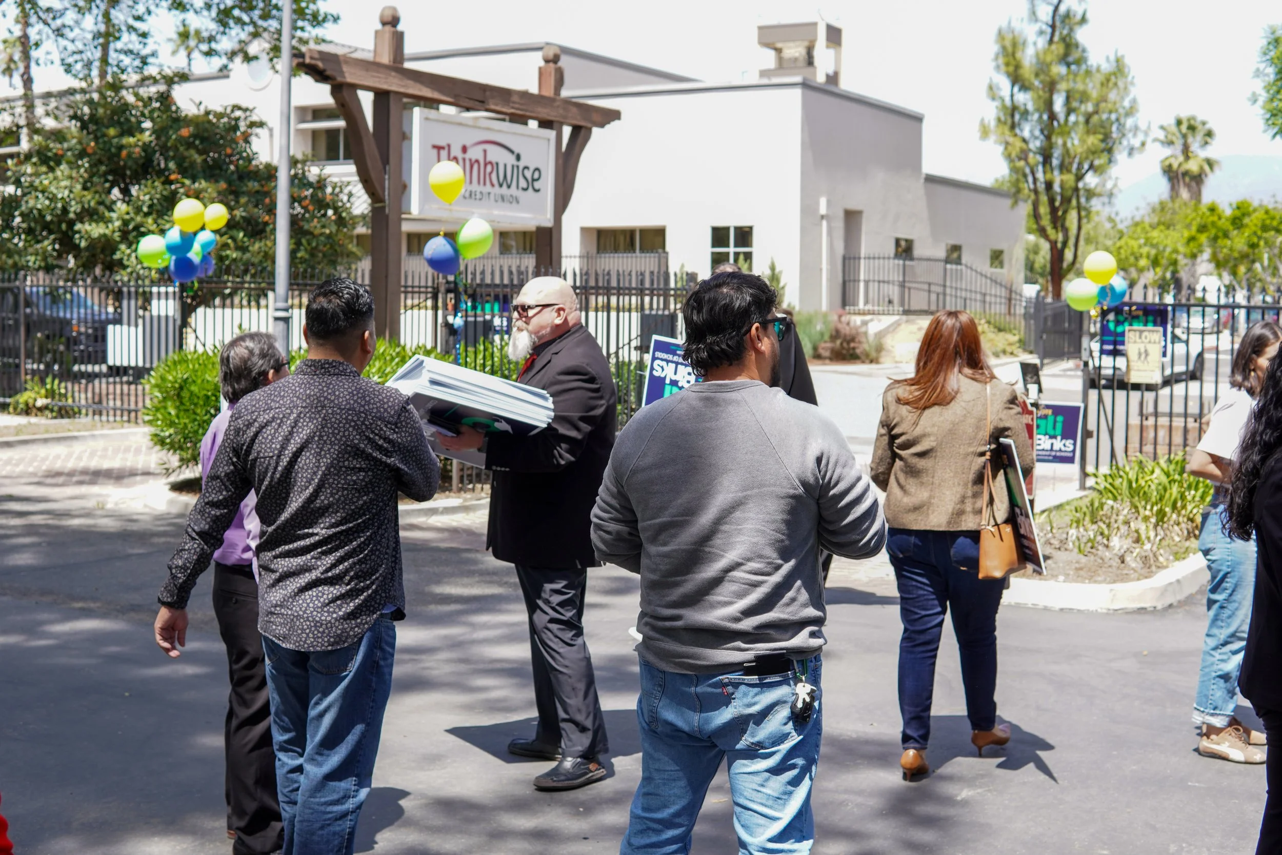 Group of community members networking while picking up yard signs.