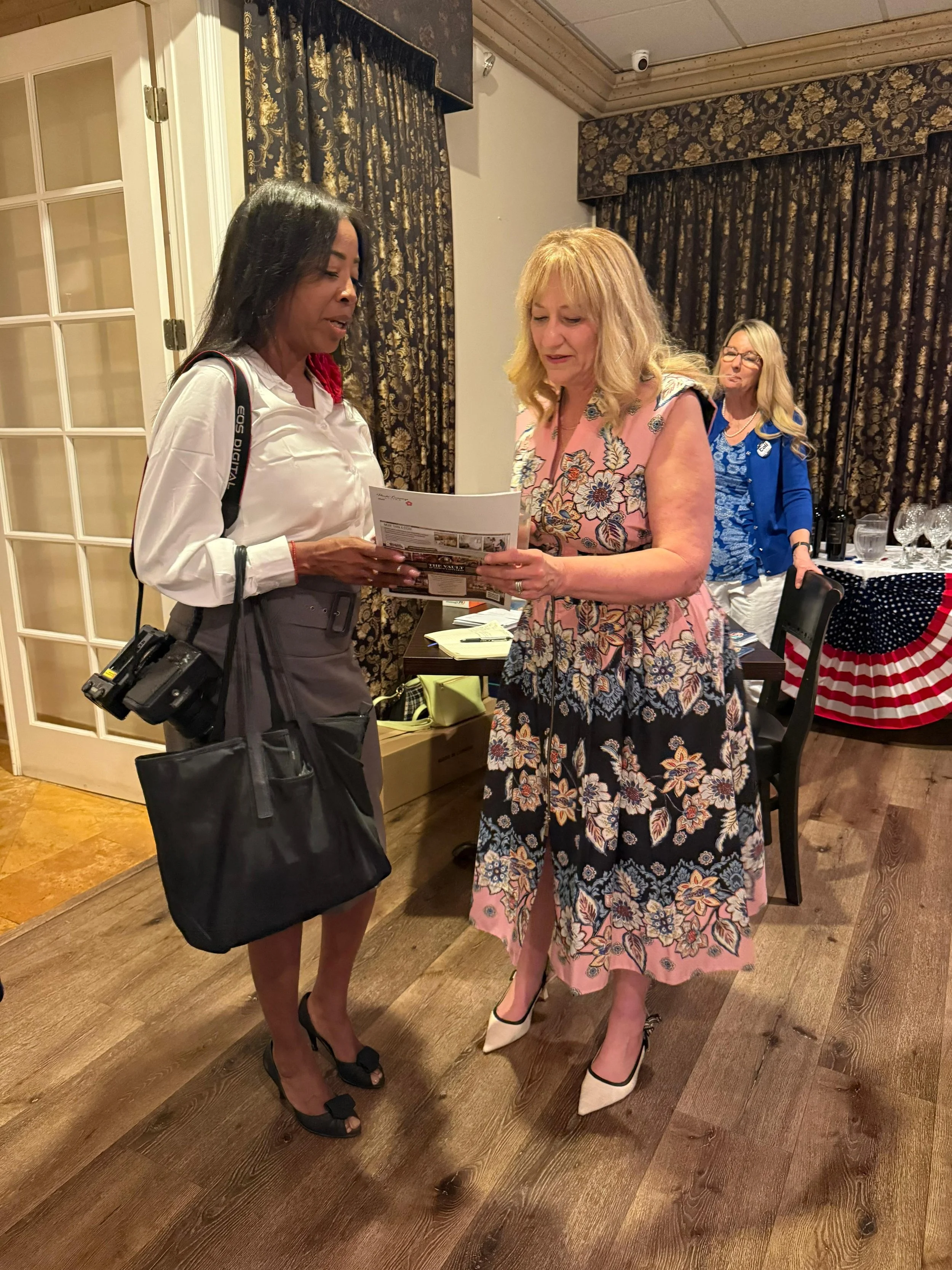 Cali Binks with a guest looking at a file at the fundraiser.