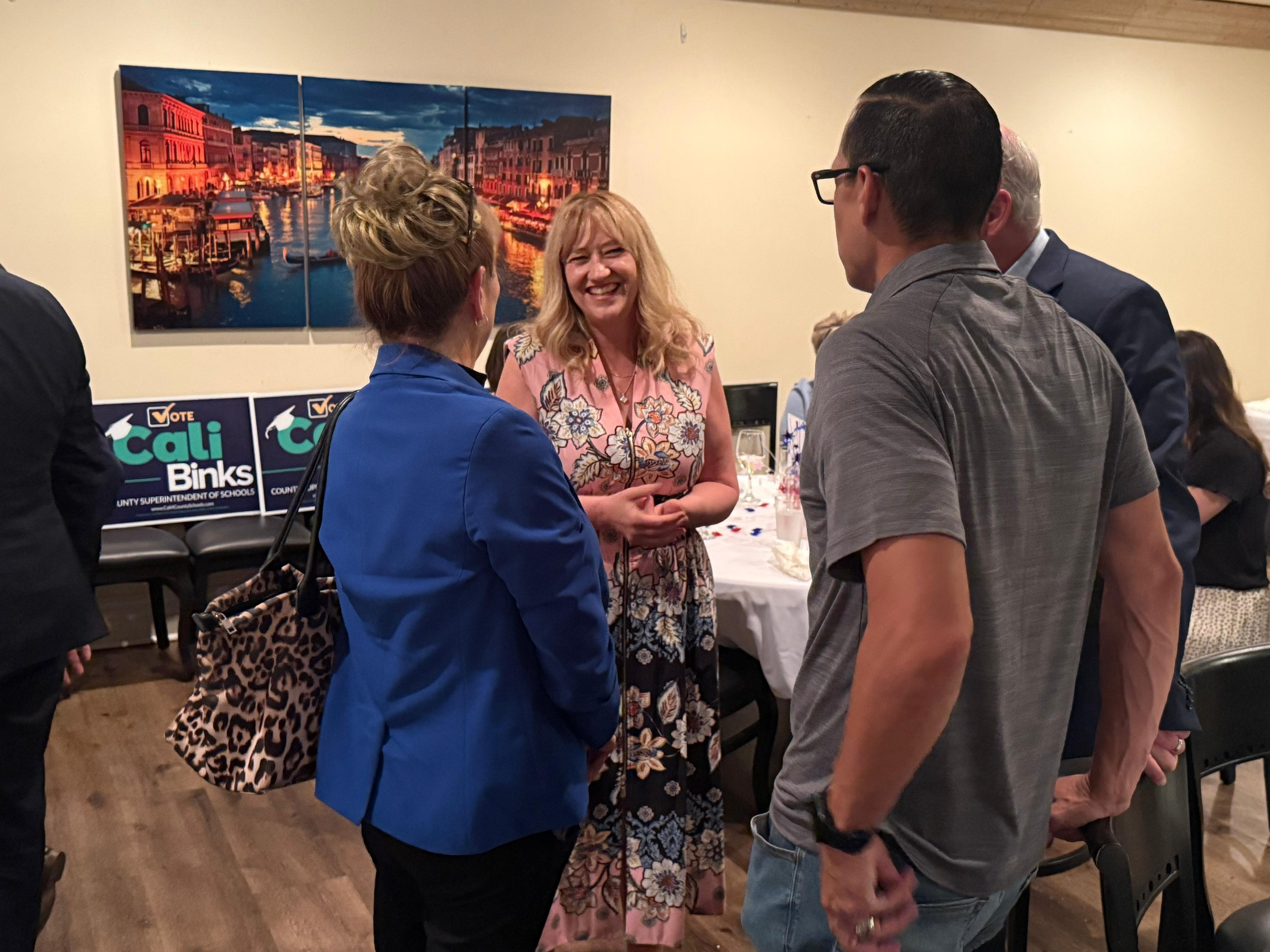 Cali Binks speaking to two guests at the fundraiser.