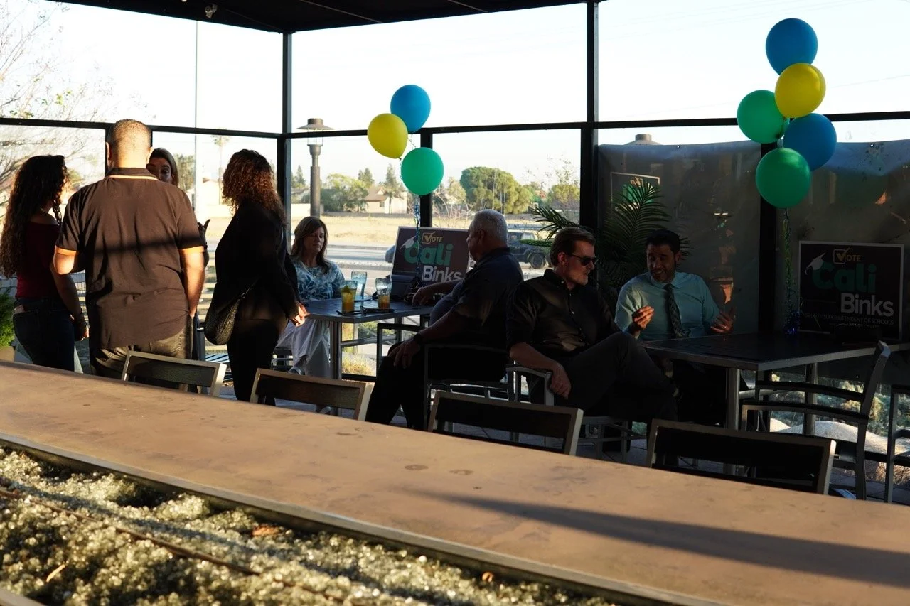 Group of guests sitting and standing gathered in groups and networking.