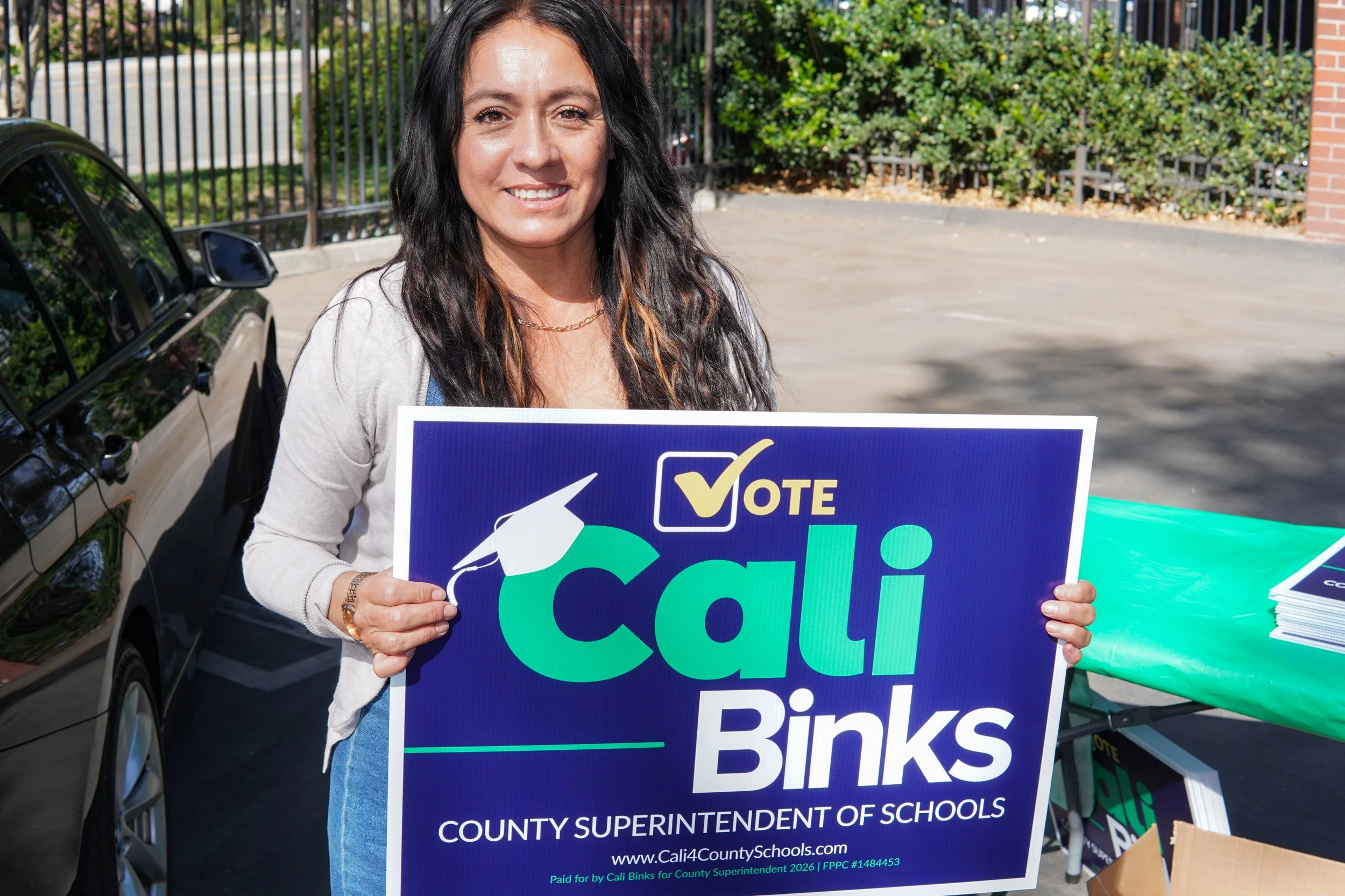 Adult holding a yard sign.