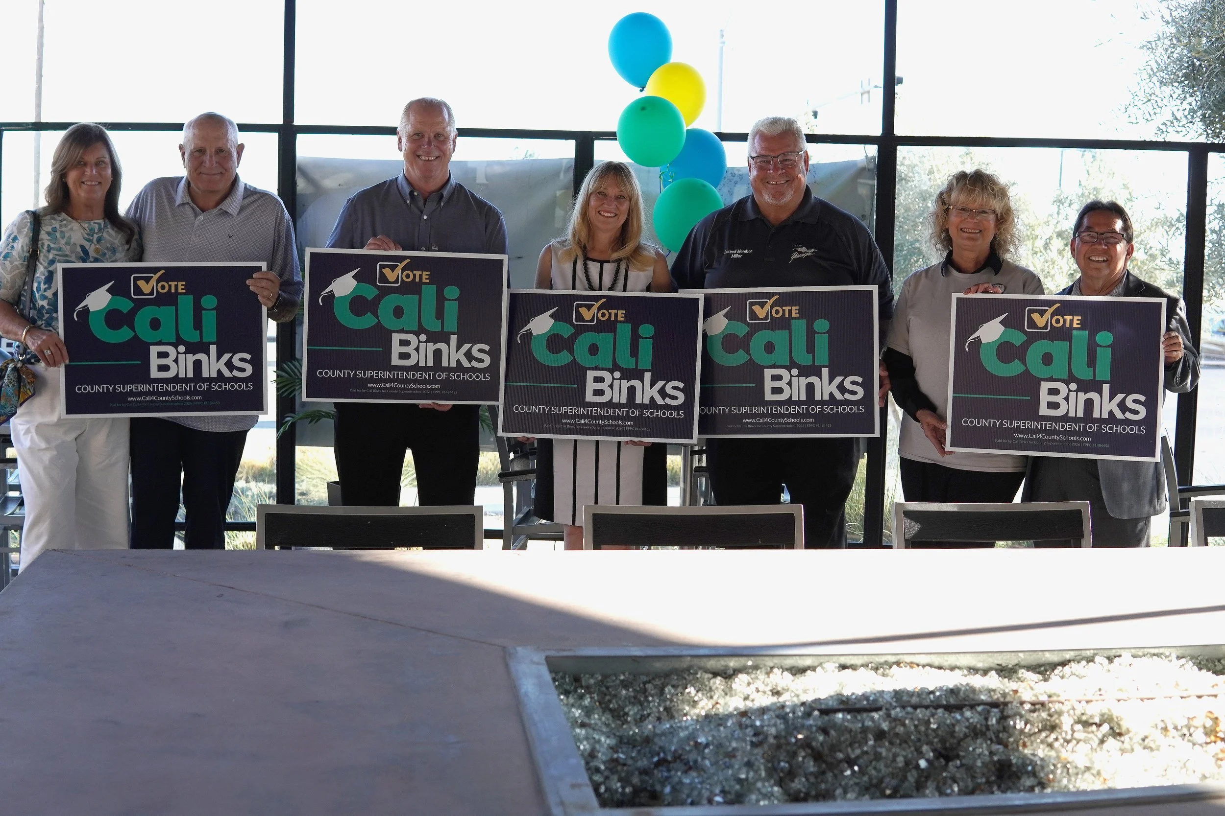Cali Binks with her husband Kelly Binks, Norm Nunez, and four Yucaipa community members holding campaign yard signs.