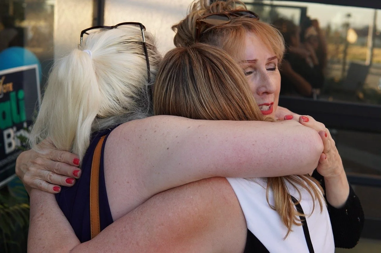 Cali hugging two friends.