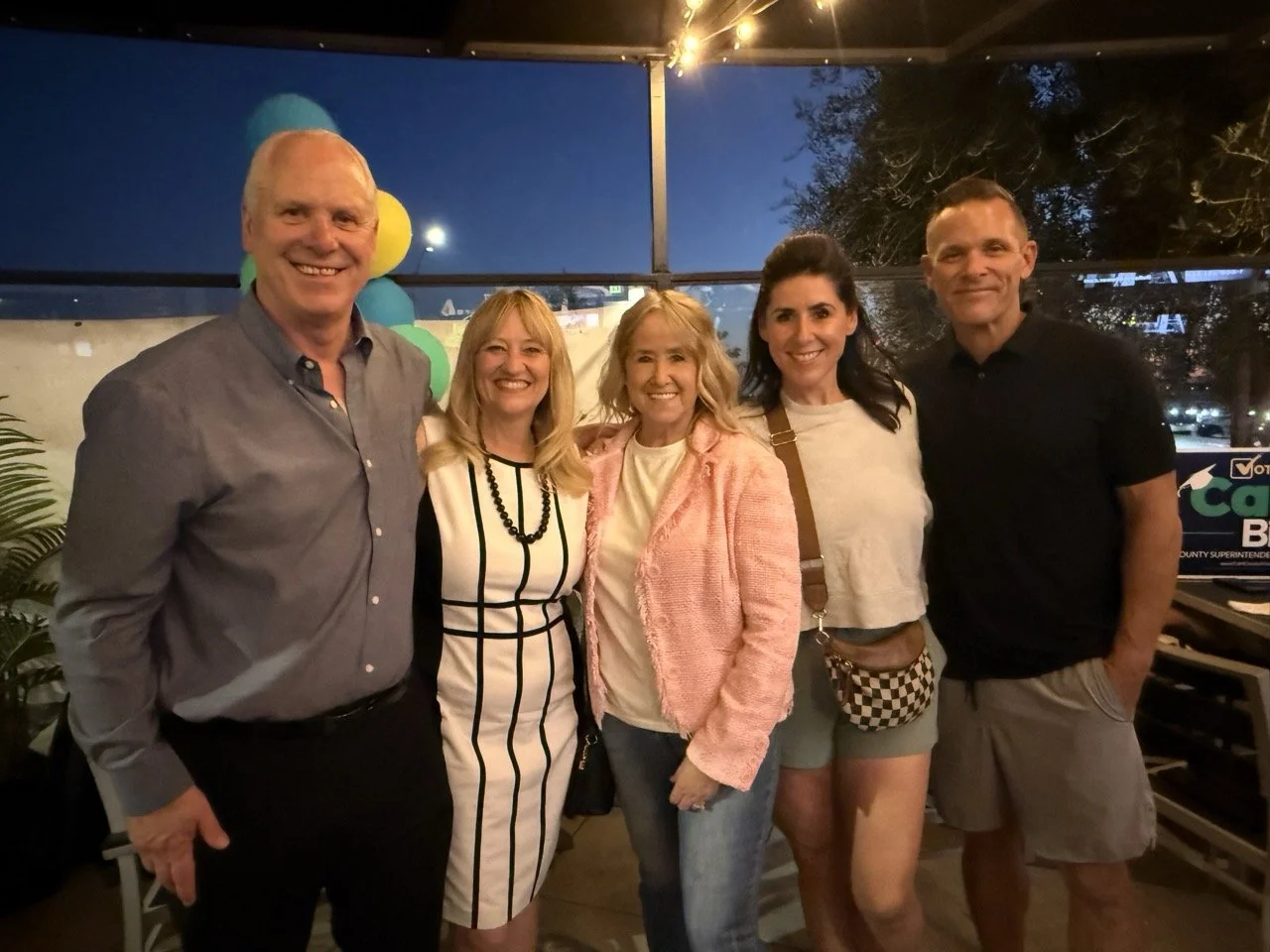 Cali and husband posing with three guests.