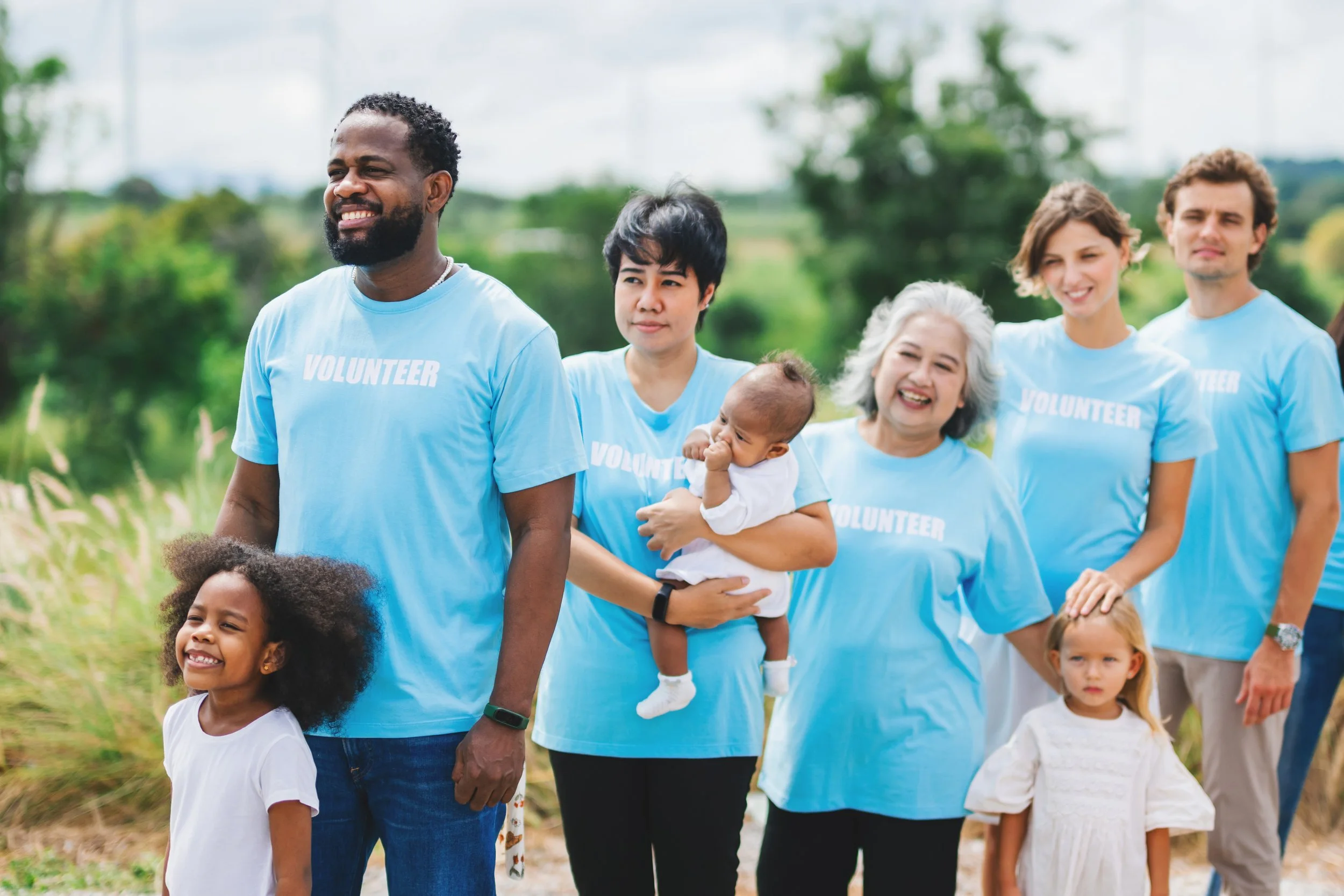 Five adults and three children volunteering in the outdoors.