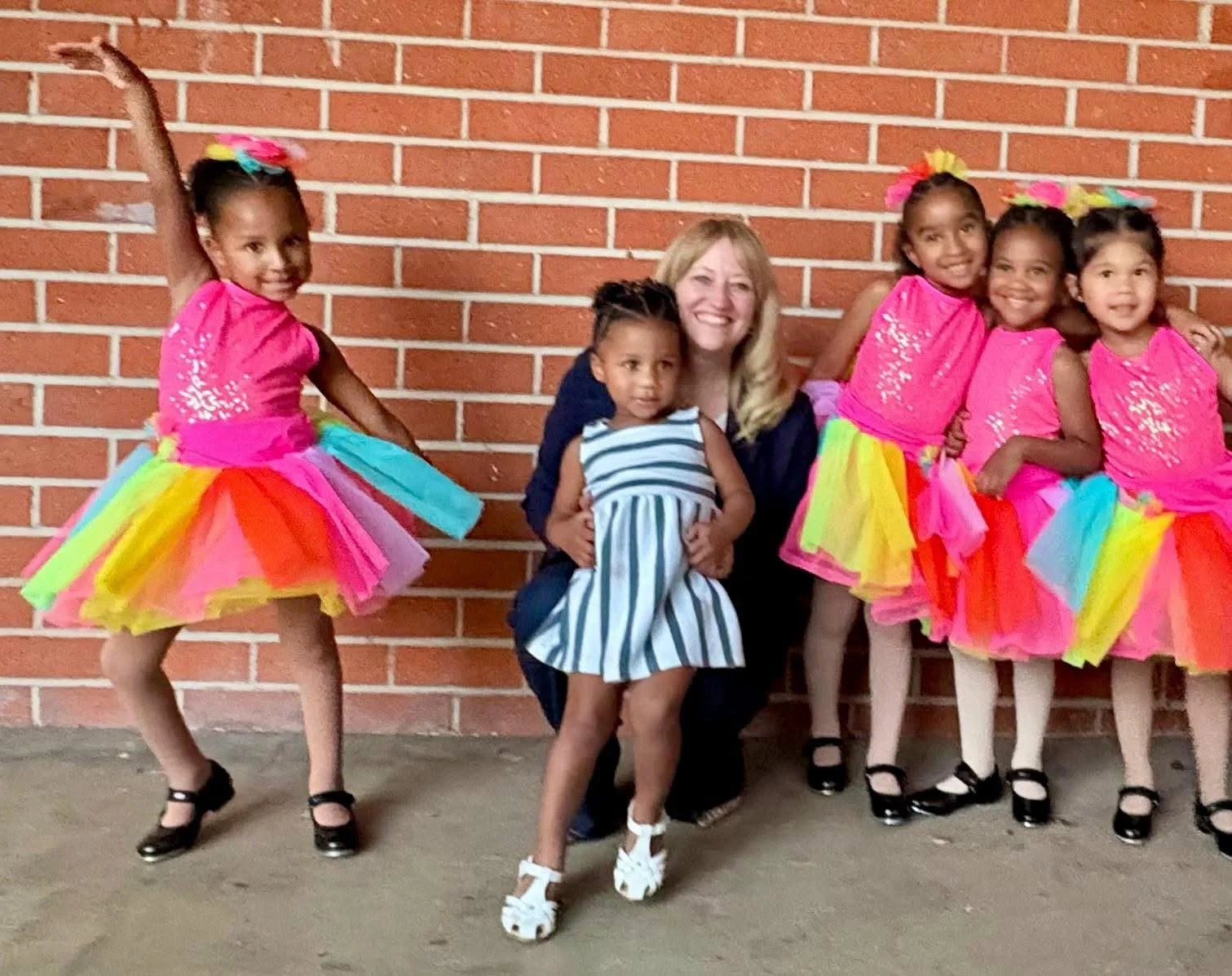 Five elementary students smiling and standing next to Cali.