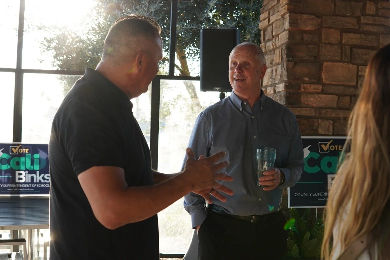 Cali's husband speaking to a guest.