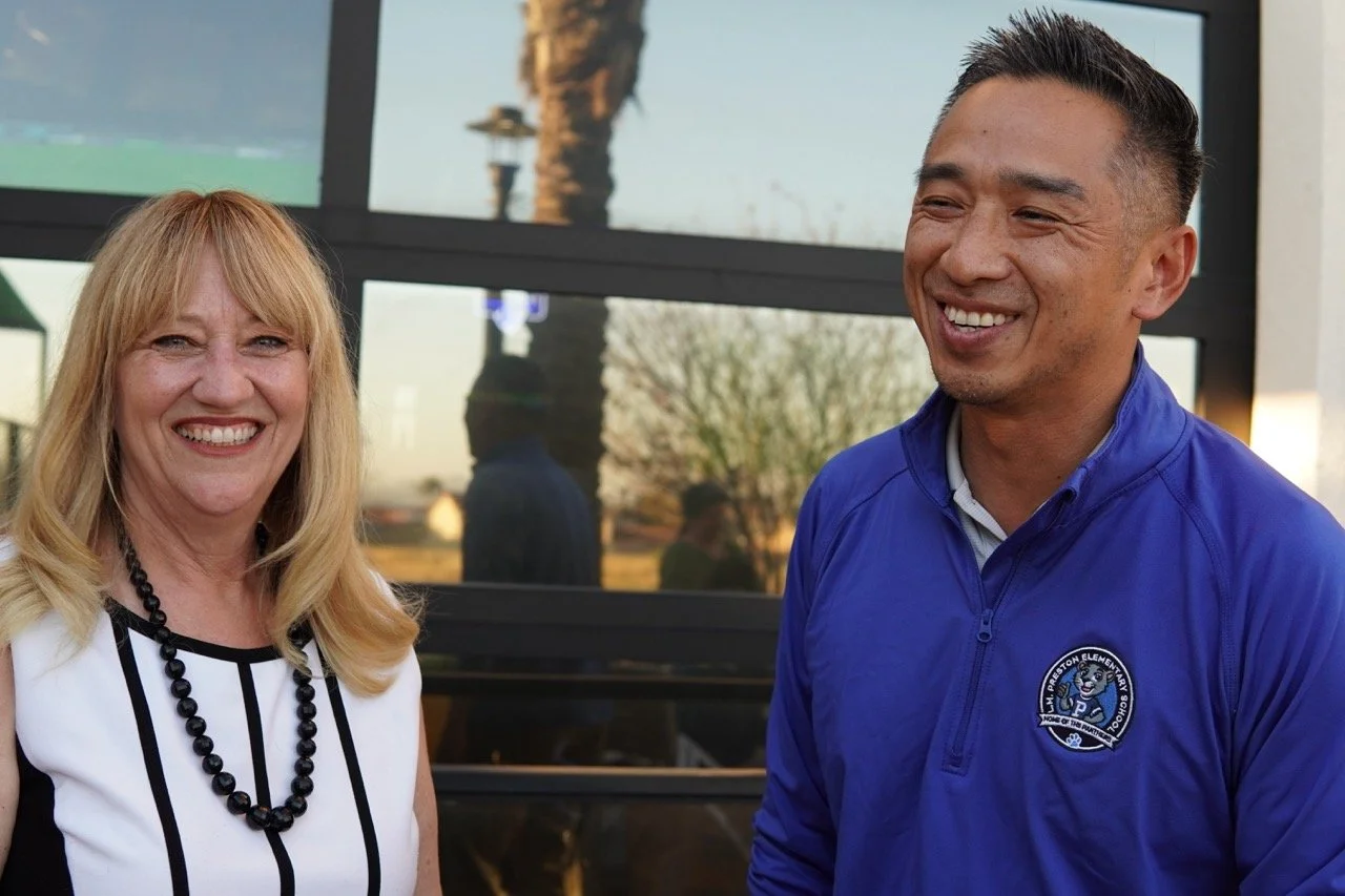 Cali smiling and speaking to a guest from Preston Elementary School.