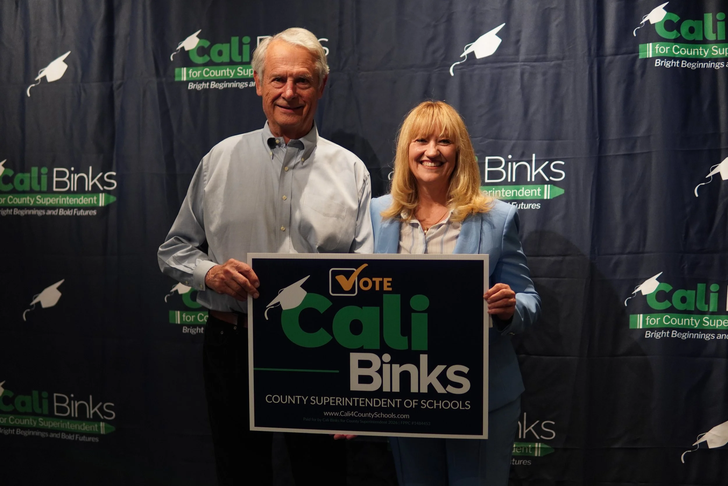 Cali with an adult holding a yard sign