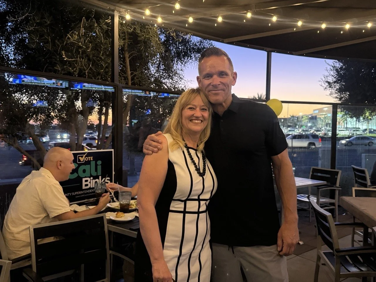 Cali hugging and posing with community member.