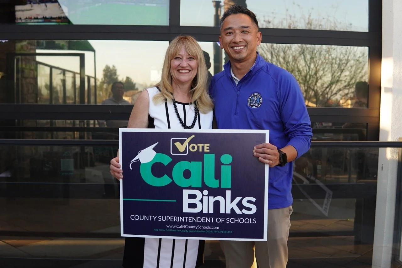 Cali posing with a guest from Preston Elementary School with yard sign.