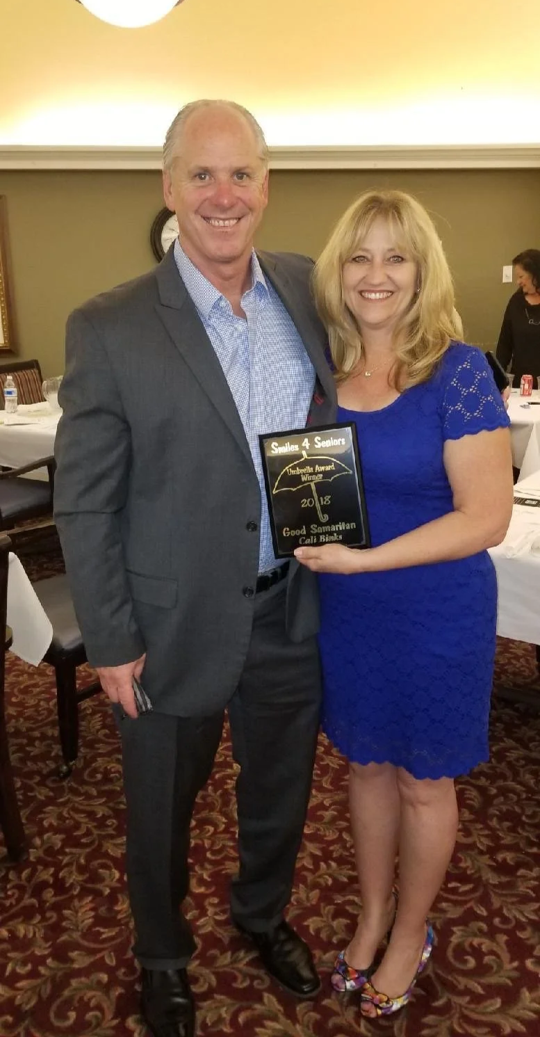 Cali standing next to her husband posing for an award.