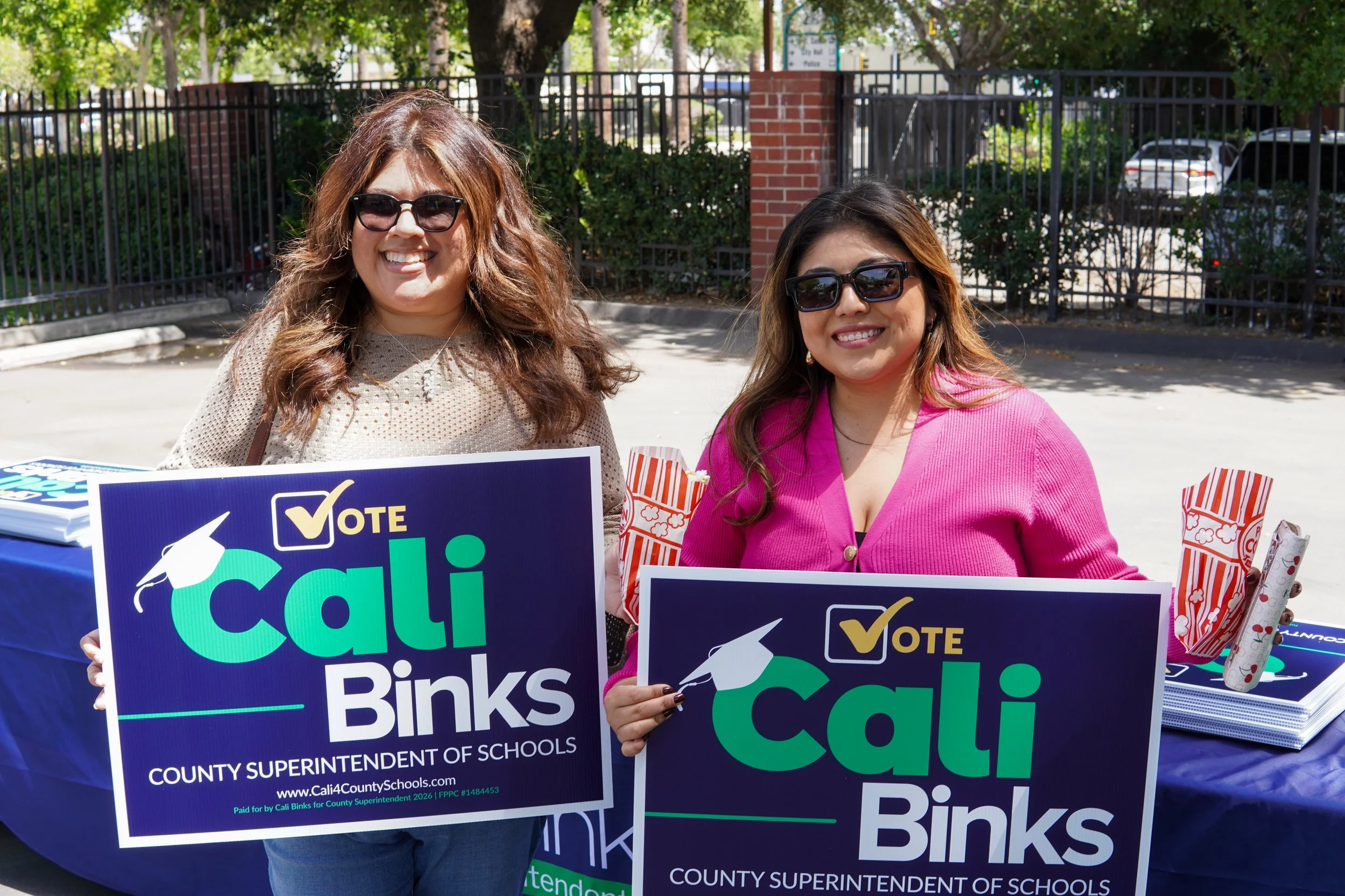 Two adults holding a yard sign in support of Cali Binks.