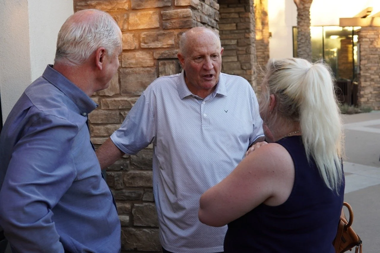 Three guests speaking in a circle at the event.
