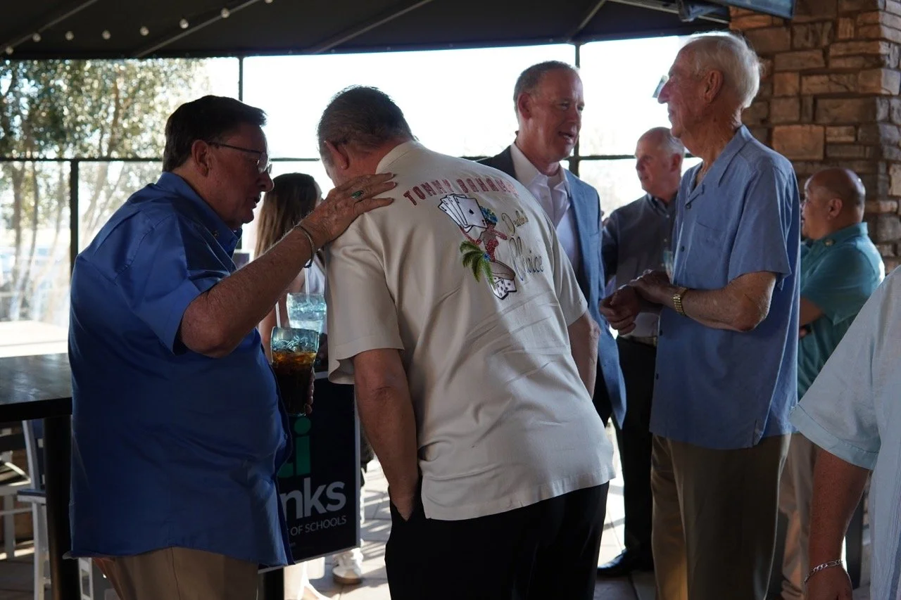 Former SBCSS Superintendent Dr. Herb Fischer is speaking to Dale Marsden surrounded by other event guests.