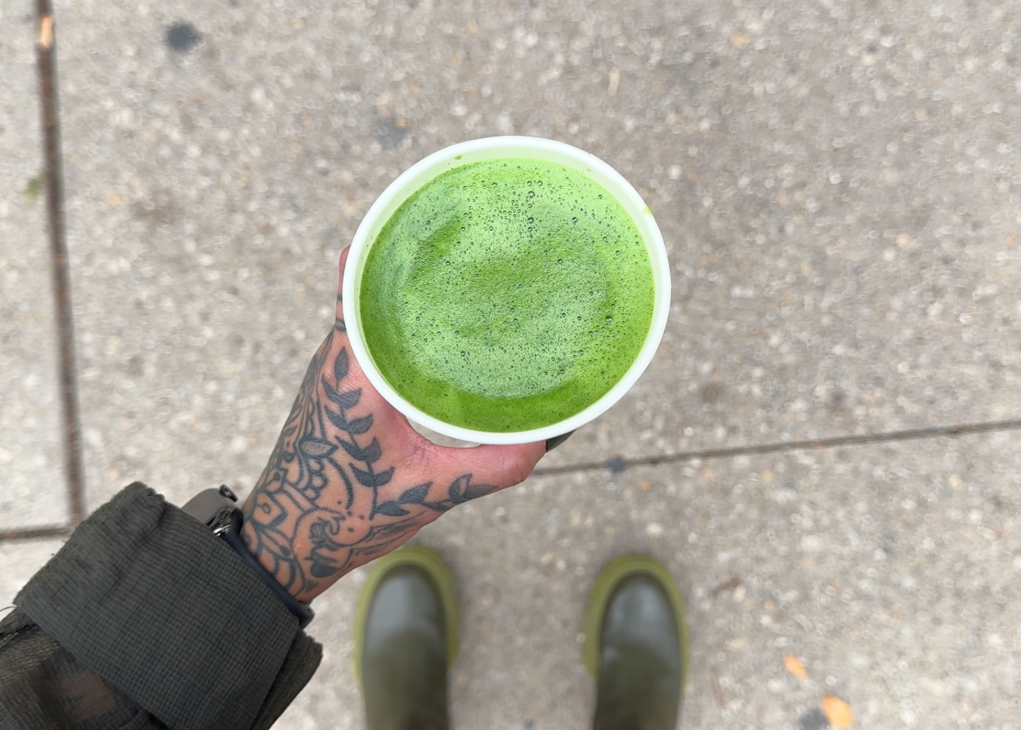Jules holding a hot matcha americano prepared within matcha’s ideal temperature range. The matcha maintained its vibrant green color.