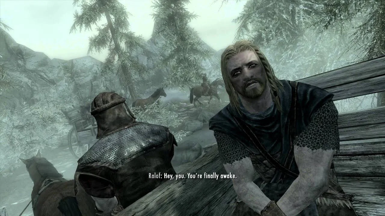 A scene from a video game showing a man with long blonde hair and a beard sitting on a bench, speaking to another man with a hood and armor, with two horses and a snowy forested landscape in the background.
