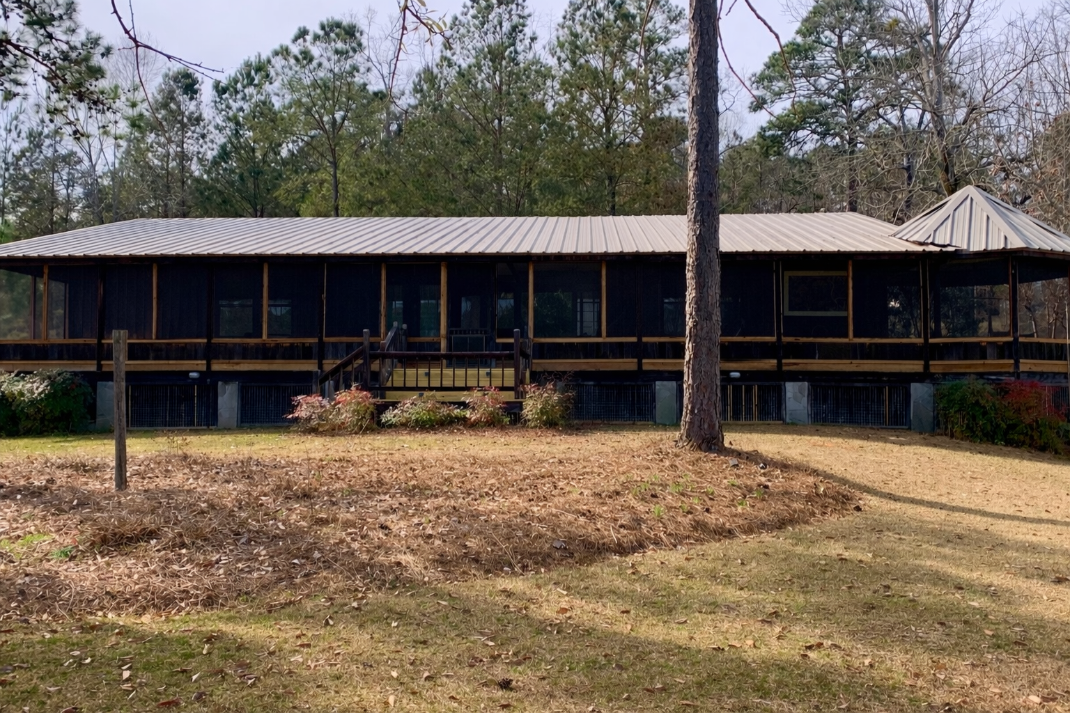 A full-length screened porch designed to enhance outdoor living, thoughtfully integrated with the home's structure and surrounding landscape for both function and visual balance.  