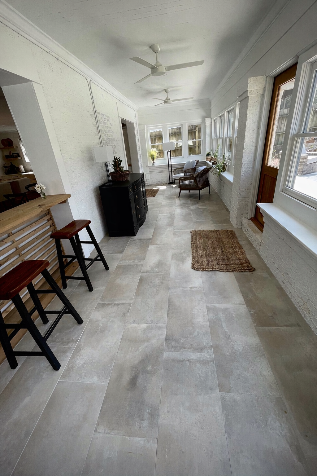 Bright sunroom renovation designed to maximize natural light, featuring clean lines and durable tile flooring for a fresh, comfortable living space.