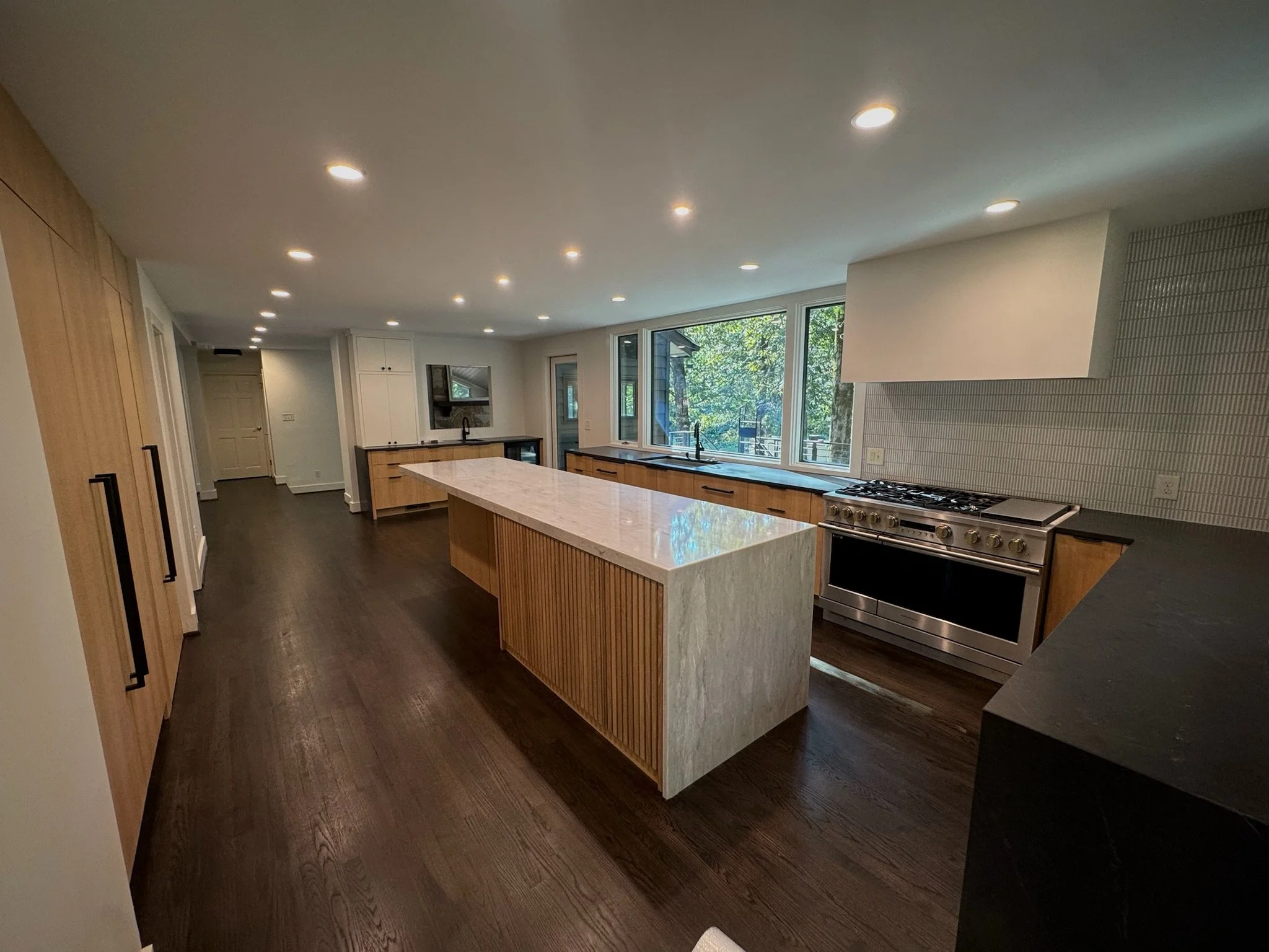 Spacious open-concept kitchen showcasing a custom island and refined finishes, designed to maximize natural light, functionality, and seamless flow throughout the home.
